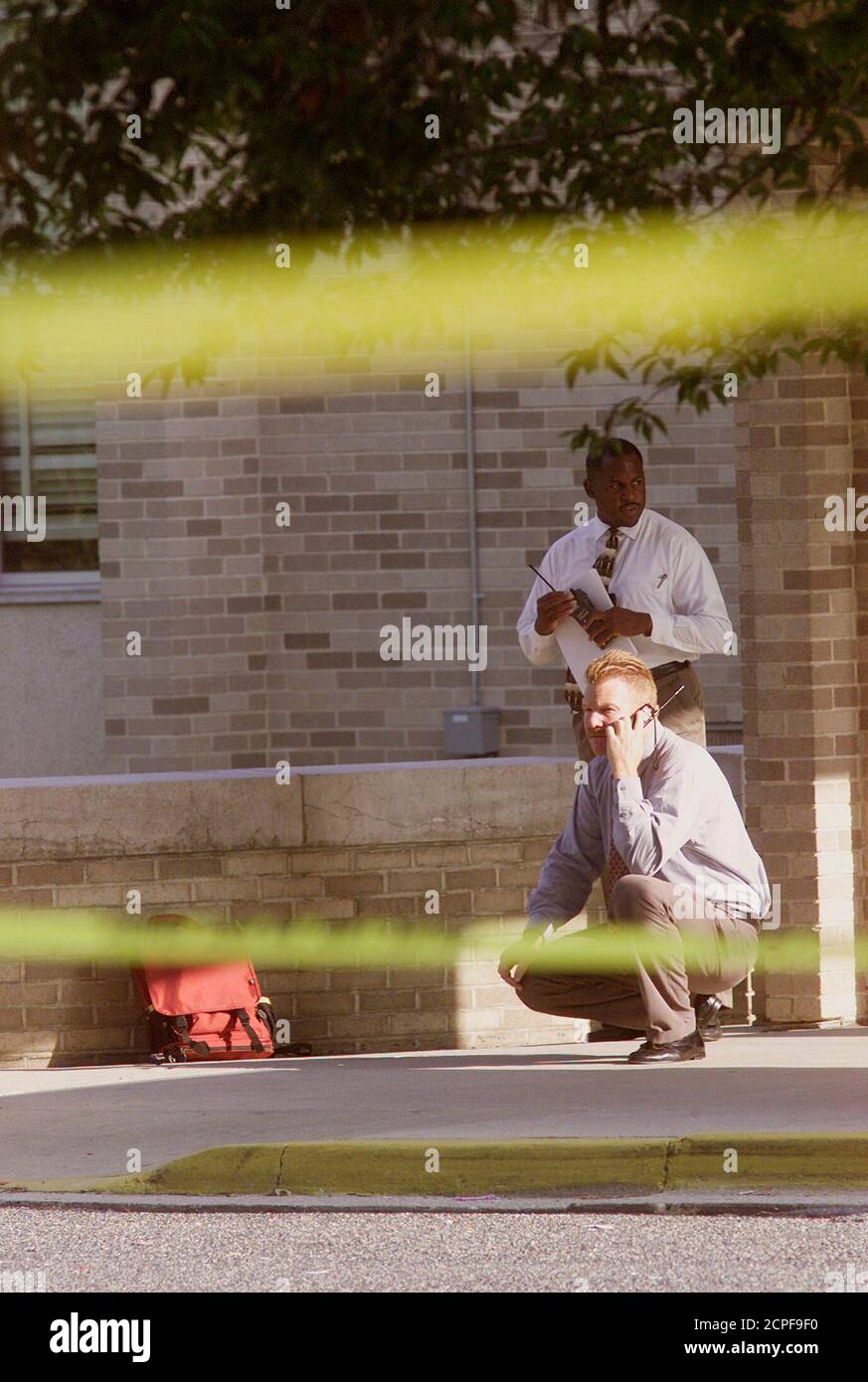 Les enquêteurs vérifient le site à l'entrée de la Benjamin Tasker Middle  School à Bowie, Maryland, où un garçon de 13 ans a été abattu et grièvement  blessé le 7 octobre 2002.