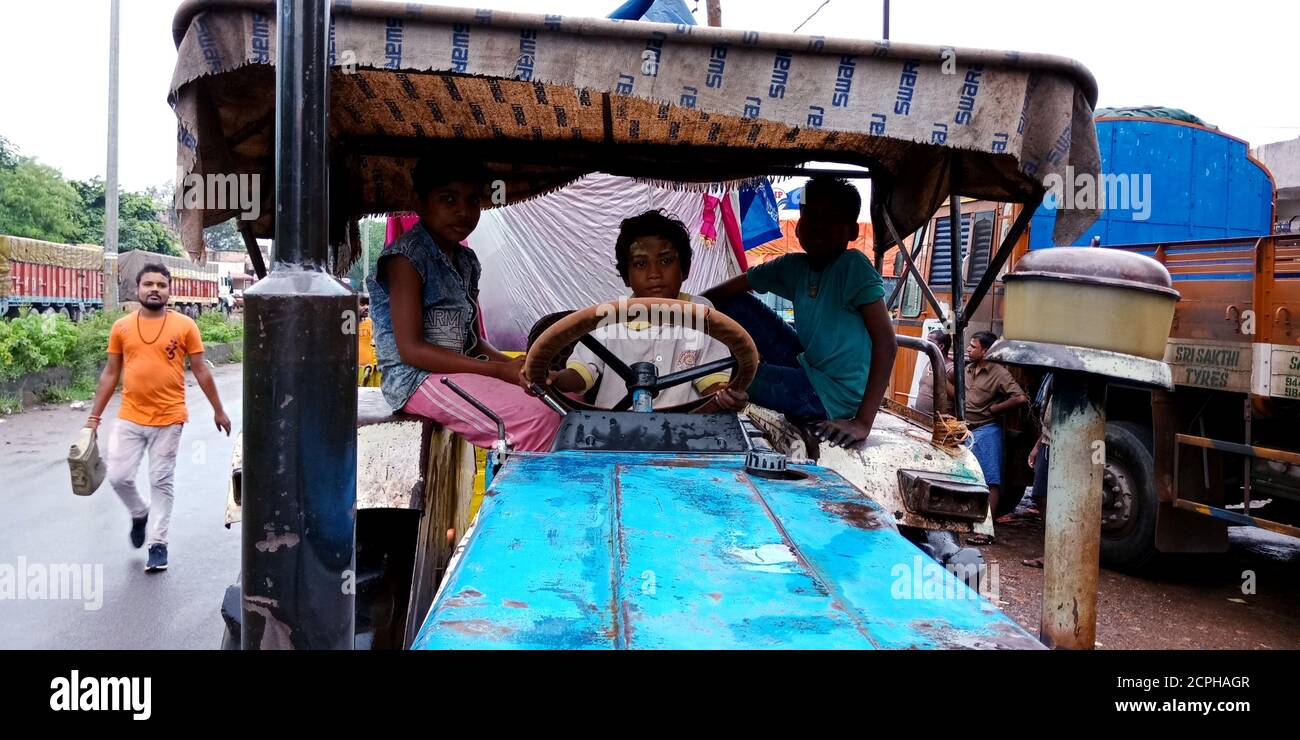 DISTRICT KATNI, INDE - 08 SEPTEMBRE 2019: Village asiatique pauvre garçon conduisant un tracteur sur route en dessous de l'âge. Banque D'Images