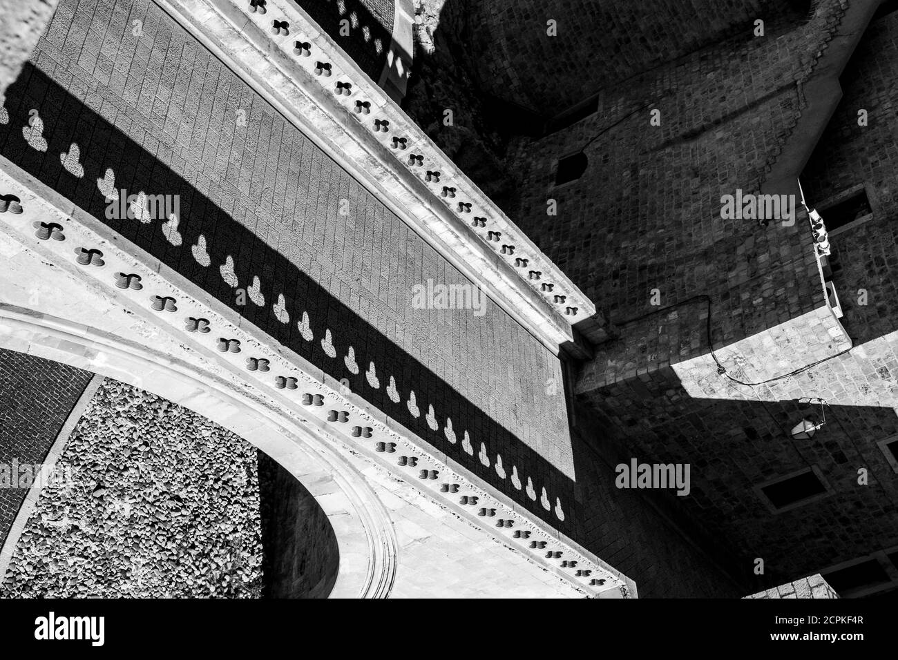 Horizon incliné, perspective abstraite noir et blanc, scène de marche de rue forteresse, pont avec ombres répétitives. Vieille ville méditerranéenne de Dubrovnik, célèbre voyage européen et destination historique, Croatie Banque D'Images