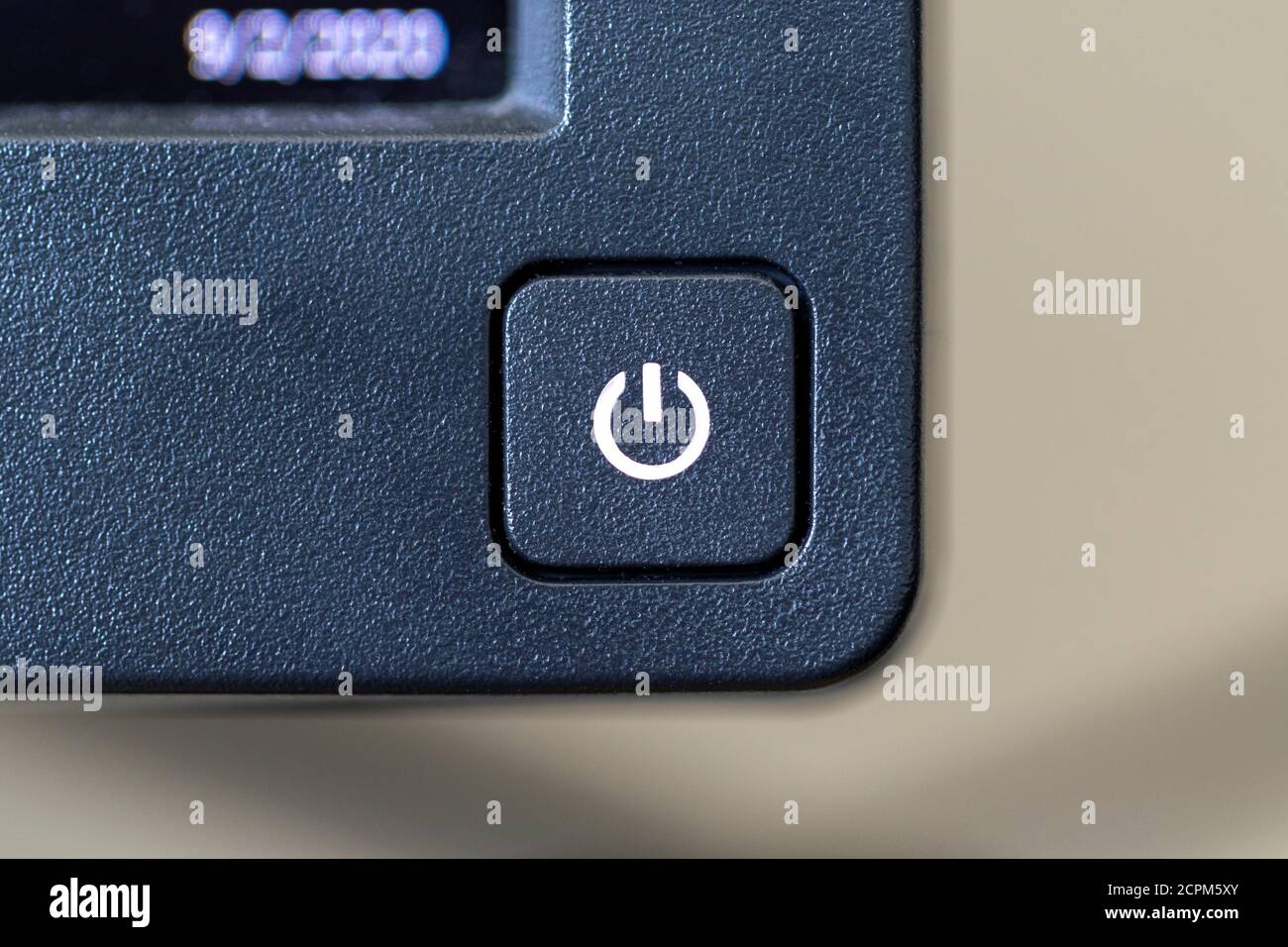 Gros plan sur le bouton marche/arrêt d'un moniteur PC. L'écran est allumé et le bouton émet de la lumière à partir du symbole Marche ou Arrêt. Banque D'Images