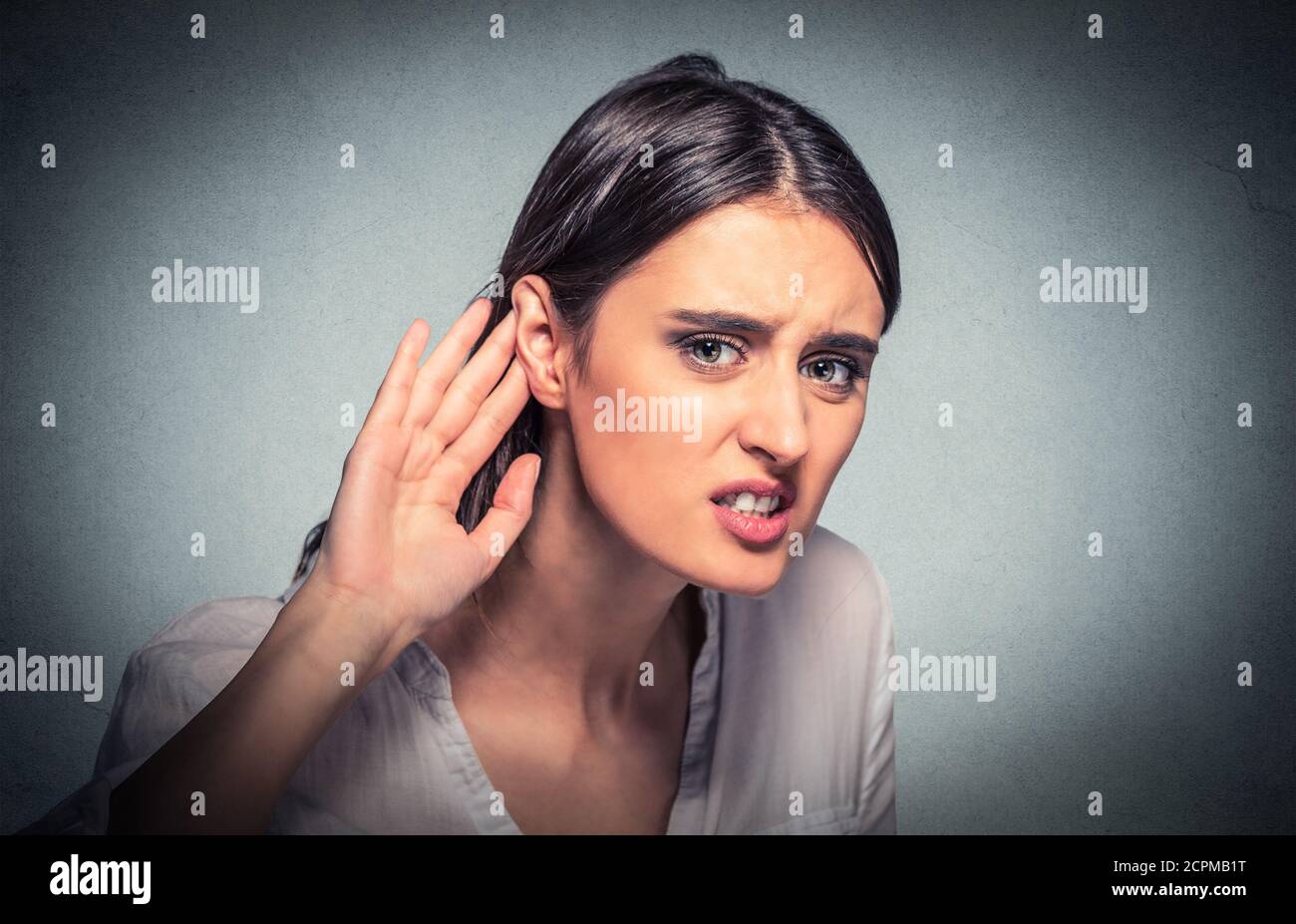 Gros plan portrait jeune femme nez gestuelle de la main à l'oreille essayant d'écouter attentivement sur juteuse conversation sur fond gris isolé. Visage humain ex Banque D'Images