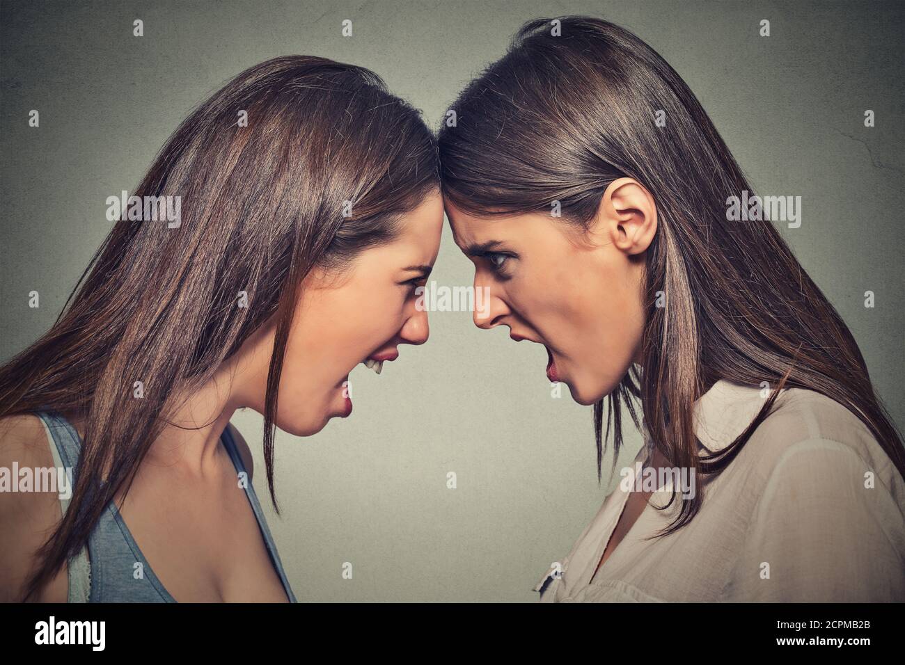 Deux femmes se battent. Les femmes en colère crient à se regarder les unes les autres avec la haine, accusant le problème. Difficultés d'amitié, problèmes au travail concept Banque D'Images