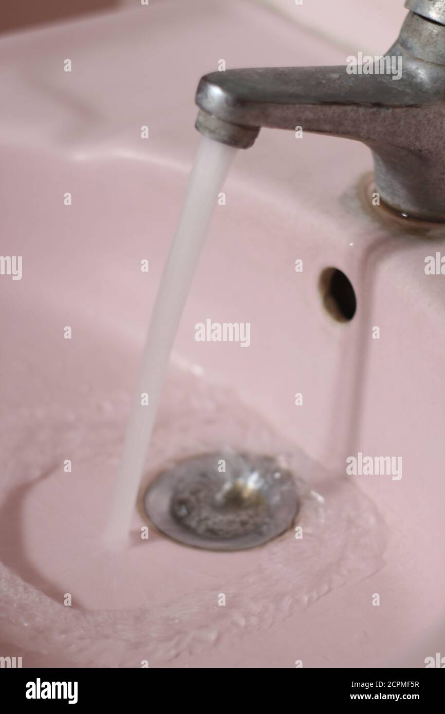 eau s'écoulant du robinet dans la salle de bains Banque D'Images