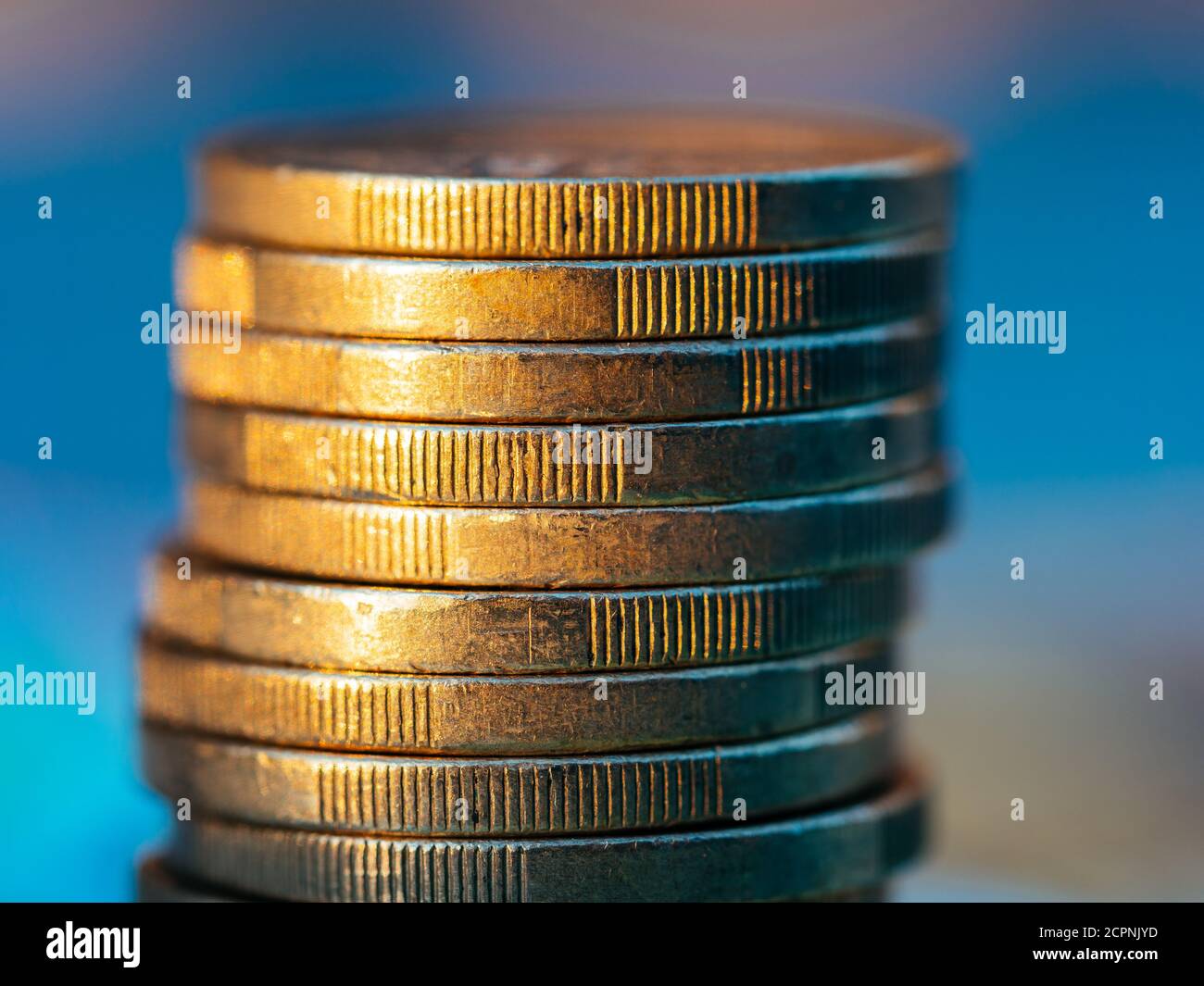 Vue rapprochée de la pile de pièces euro sur fond bleu. Banque D'Images