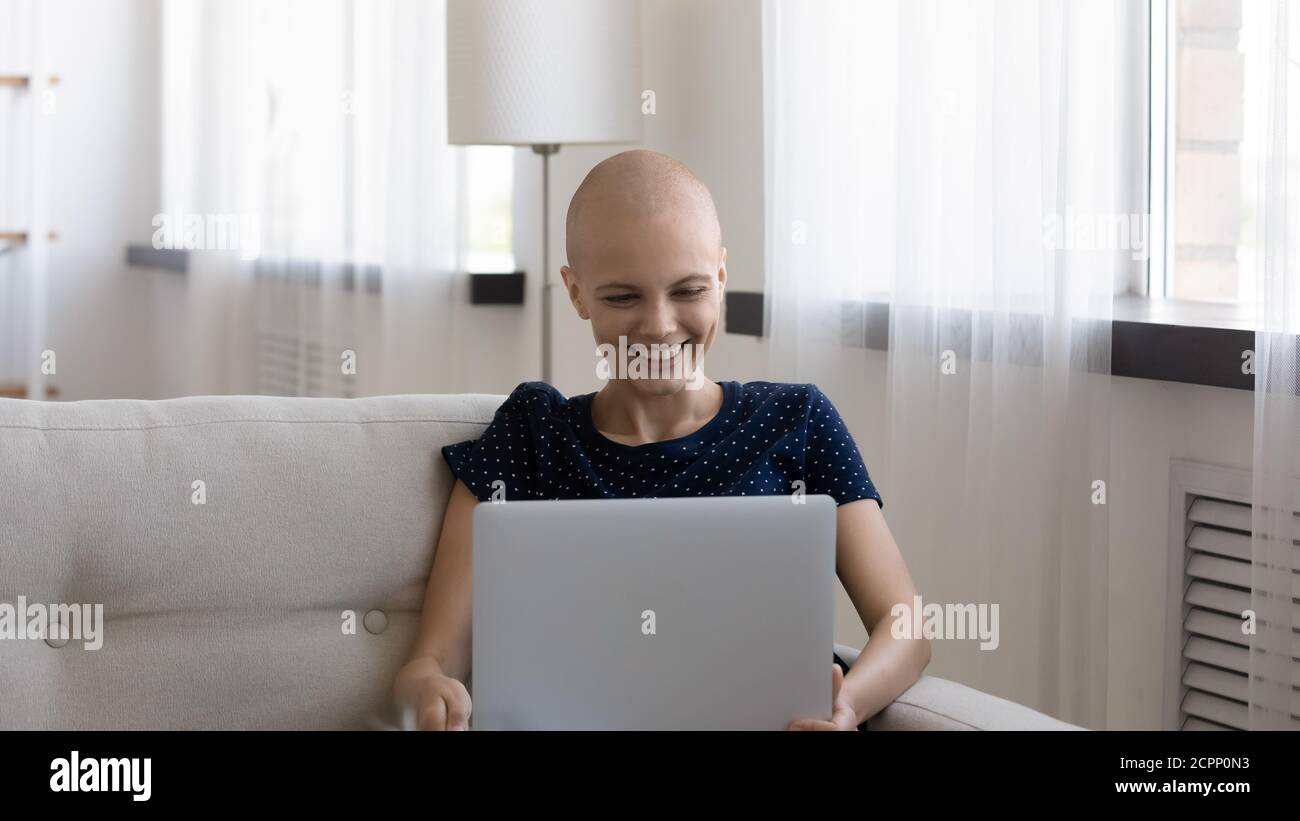 Bonne malade jeune femme se détendre à la maison avec un ordinateur portable Banque D'Images