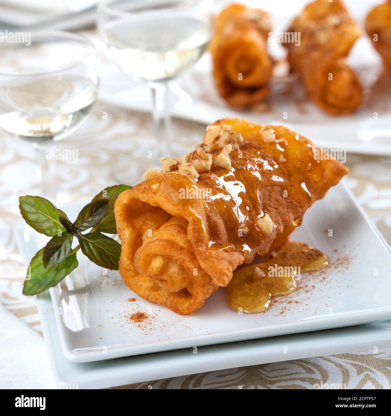 Les pommes grecques sont de fines feuilles de pâte pliées tout en étant frits dans un emballage croustillant qui est égoutté avec du miel et saupoudrés de cannelle et Banque D'Images