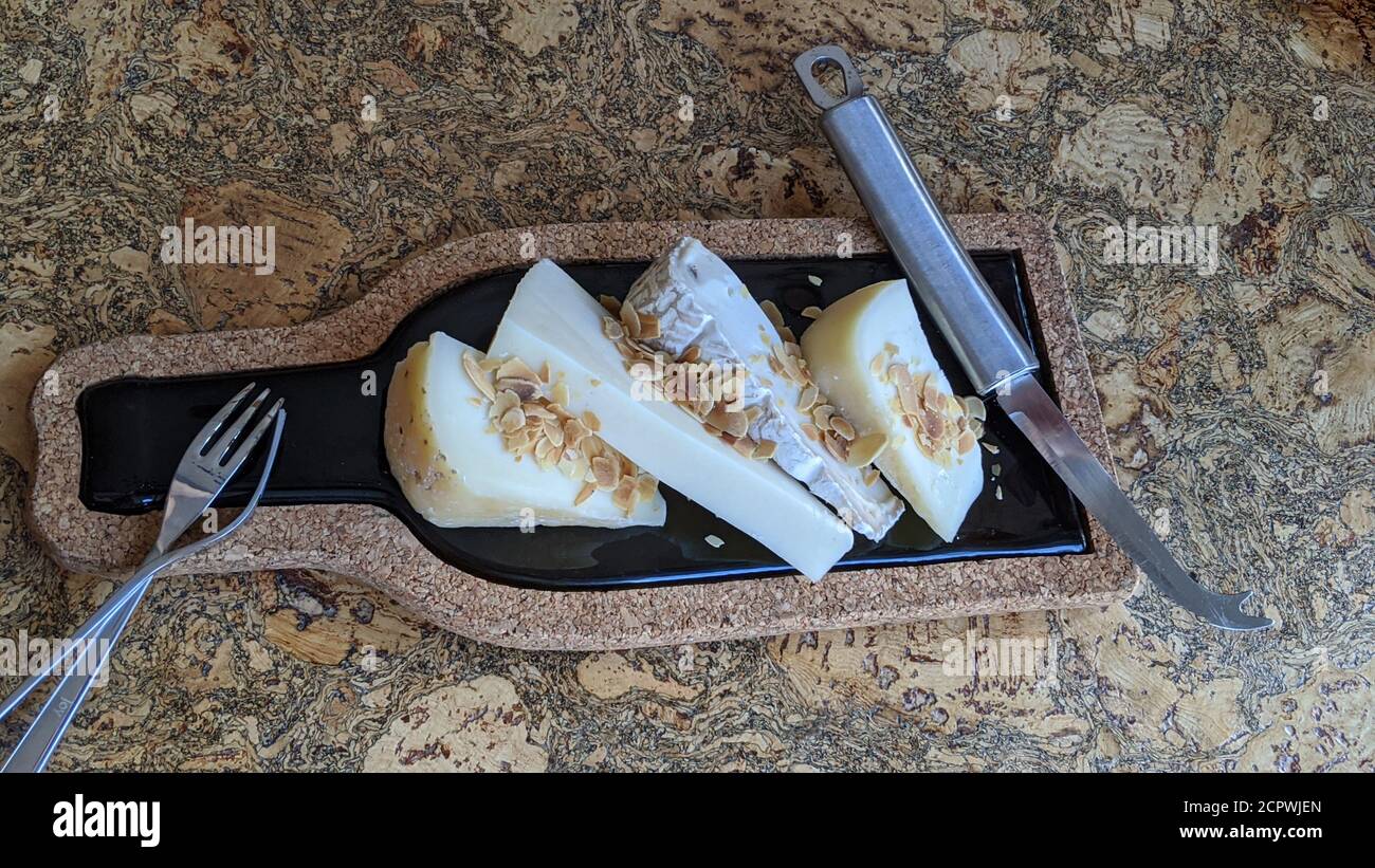 Gros plan sur la assiette de fromage. Bois et marbre avec différents types de fromage et amandes sur une table en bois. Banque D'Images