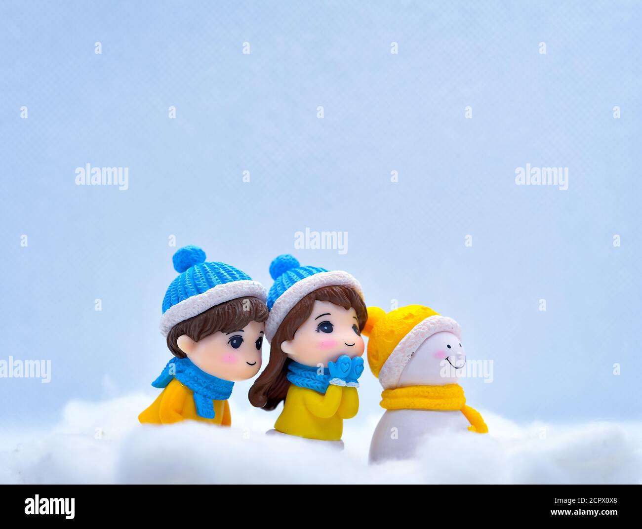 Tourisme et Voyage concept: Les personnes miniatures à la recherche de quelque chose dans la neige d'hiver avec peu de bonhomme de neige Banque D'Images