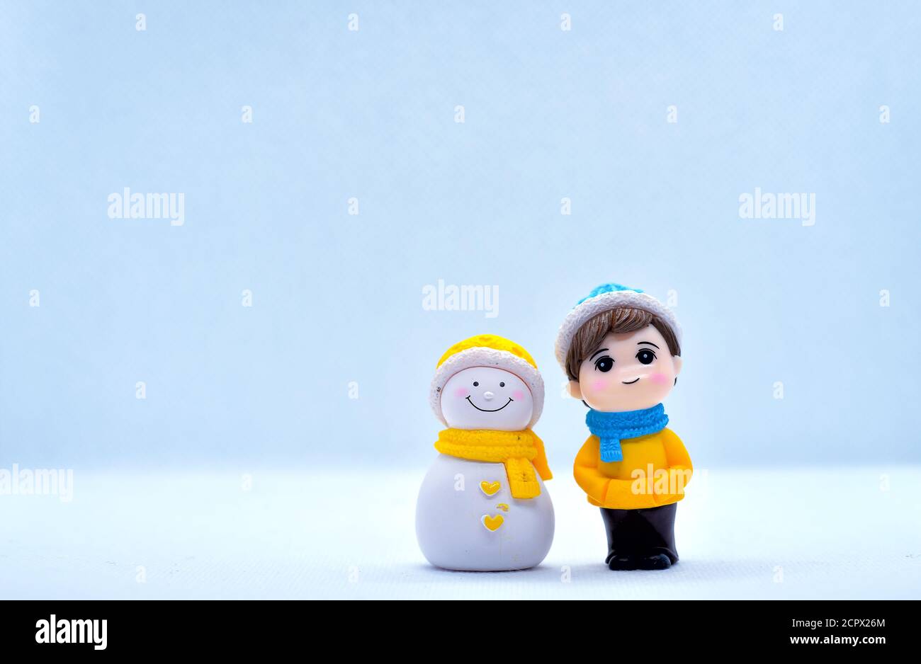 Tourisme et Voyage concept: Petit garçon miniature et bonhomme de neige debout dans un arrière-plan isolé Banque D'Images