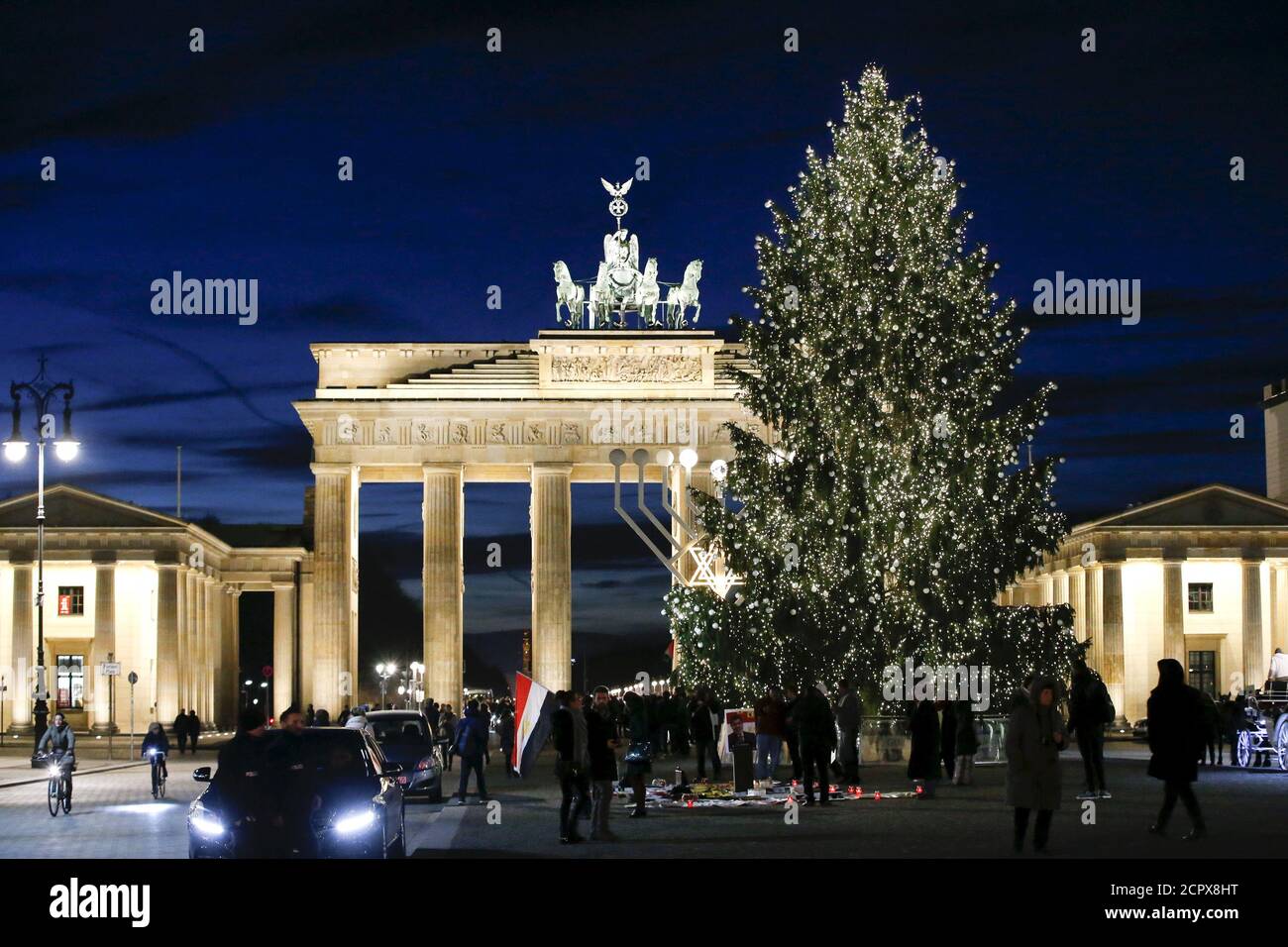 Un arbre de Noël illuminé est représenté devant la porte de Brandebourg à Berlin, en Allemagne, le 10 décembre 2015. L'humble arbre de Noël a une histoire riche, des arbres à feuilles persistantes utilisés pour symboliser la vie éternelle dans l'Égypte ancienne à l'adoration des arbres parmi les Européens païens. La version moderne a ses origines en Allemagne, où la chanson 'O Tannenbaum' est toujours un favori de fête. Aujourd'hui, l'arbre traditionnel avec des lumières et des décorations apparaît dans des villes comme Washington, Moscou et Beyrouth. Les constructions alternatives vont des déchets recyclés de Mexico à d'anciens cadres de fenêtres de Rakvere, en Estonie. Banque D'Images