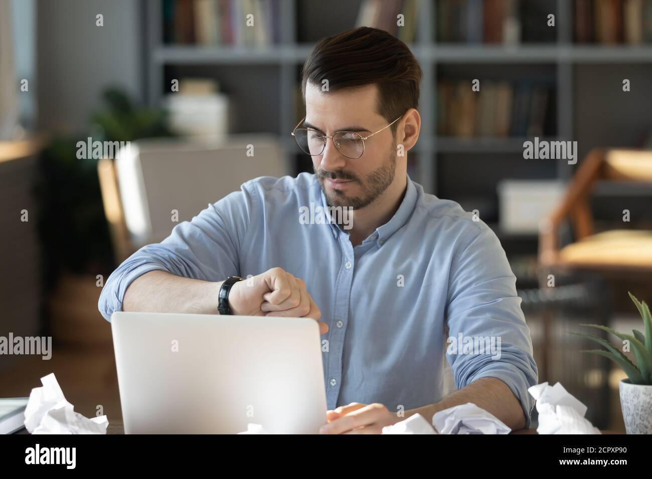 Un employé inquiet s'est inquiété de vérifier son temps avant la date limite sur le lieu de travail Banque D'Images