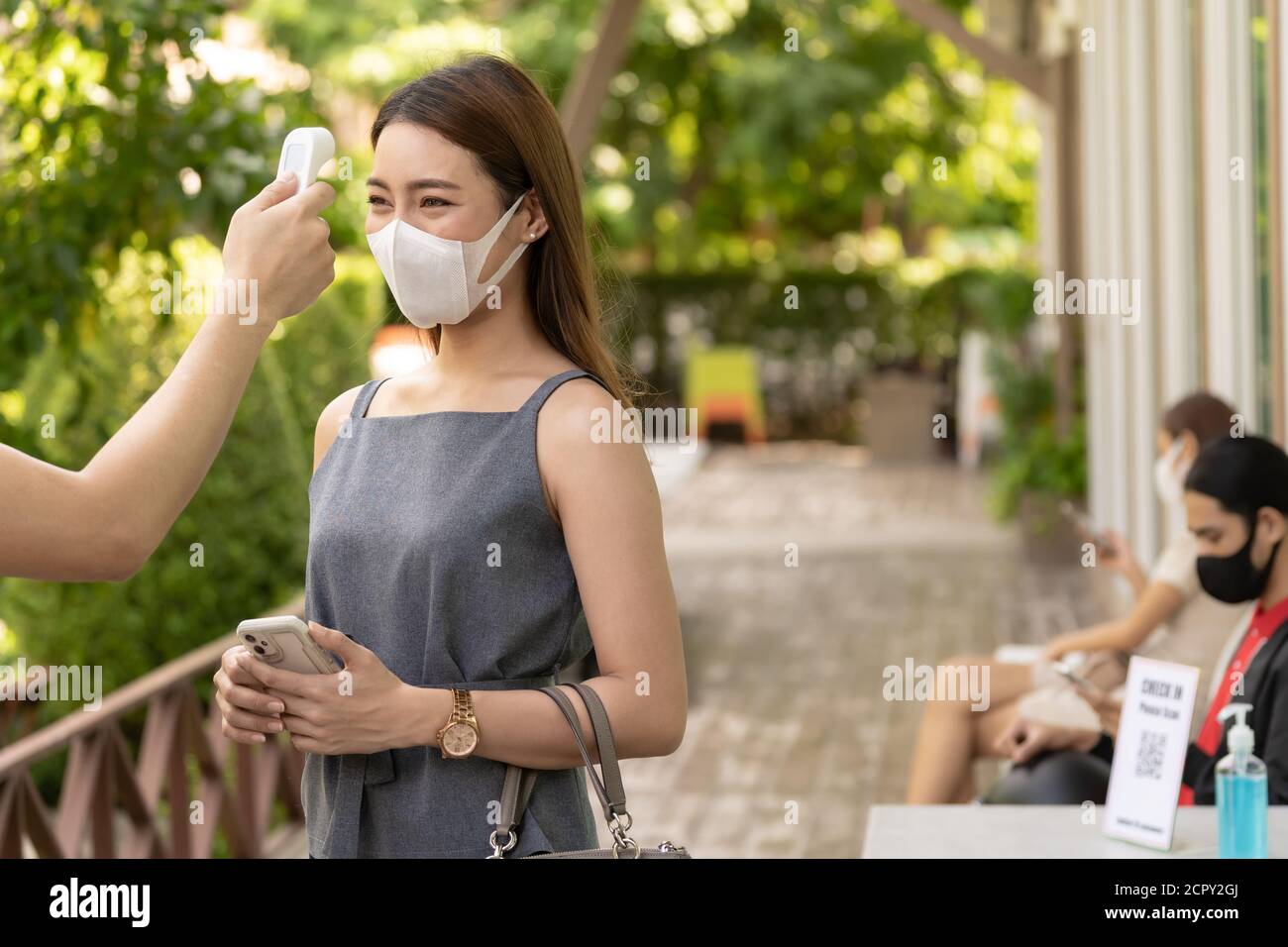 Prenez la température pour le client avec masque avant d'entrer dans le restaurant avec la file d'attente de distance sociale dans la ligne nouveau normal après le coronavirus covid-19 PAN Banque D'Images