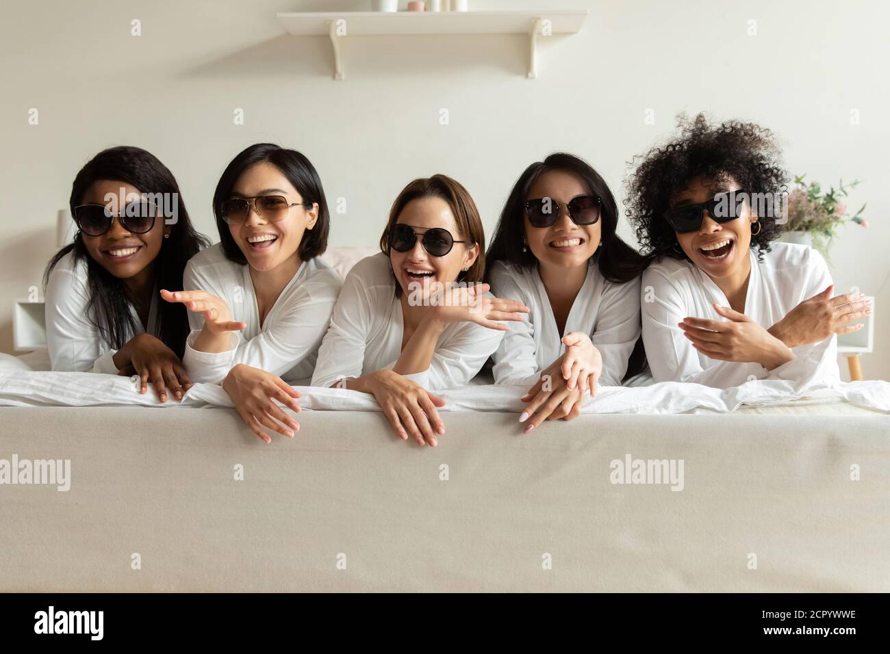 Jeune attirante divers funky femmes meilleurs amis allongé sur le lit. Banque D'Images