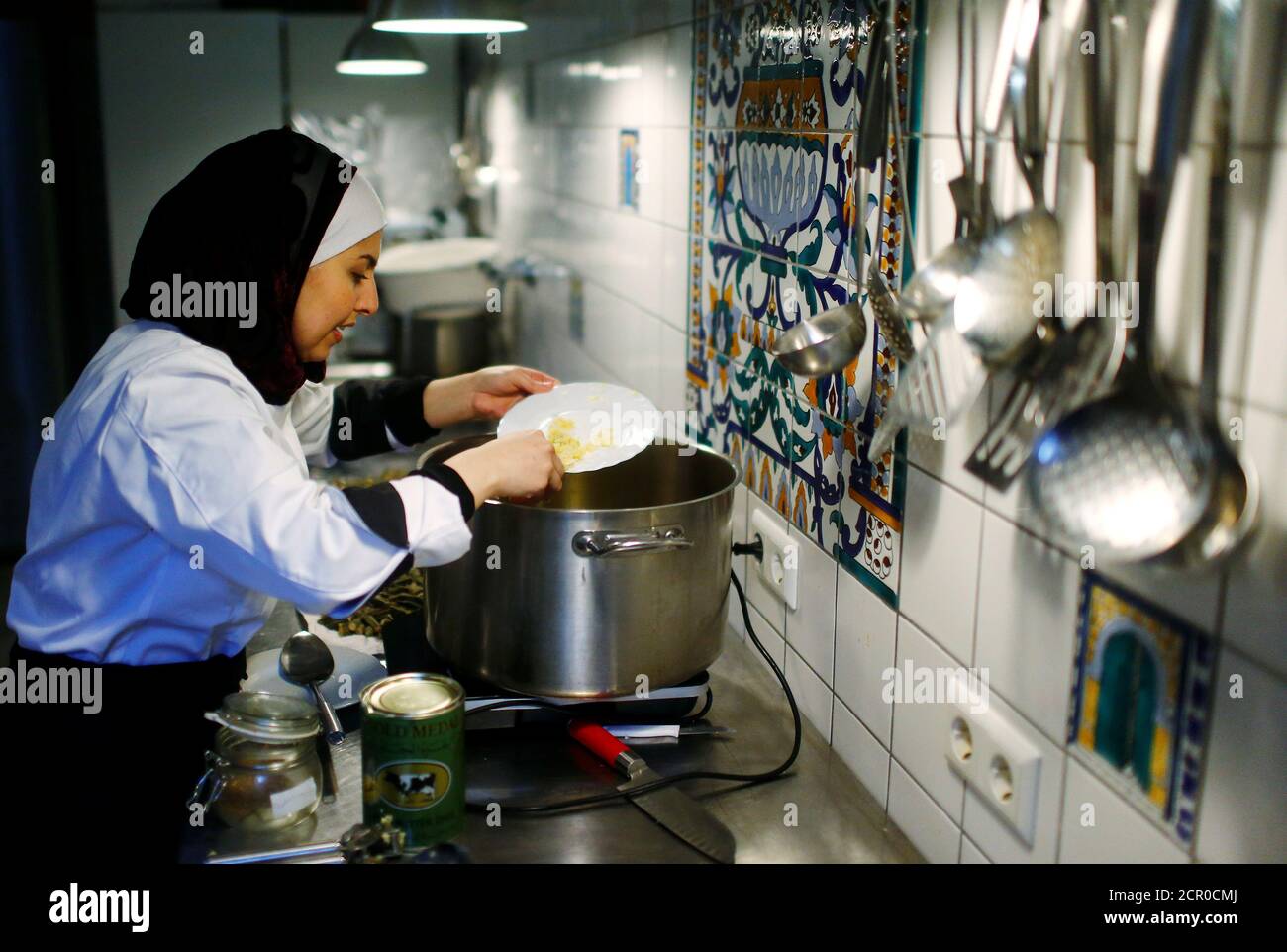 Le migrant syrien Malakeh Jazmati cuisine dans une cuisine de café à Berlin, Allemagne le 23 janvier 2018. REUTERS/Hannibal Hanschke Banque D'Images