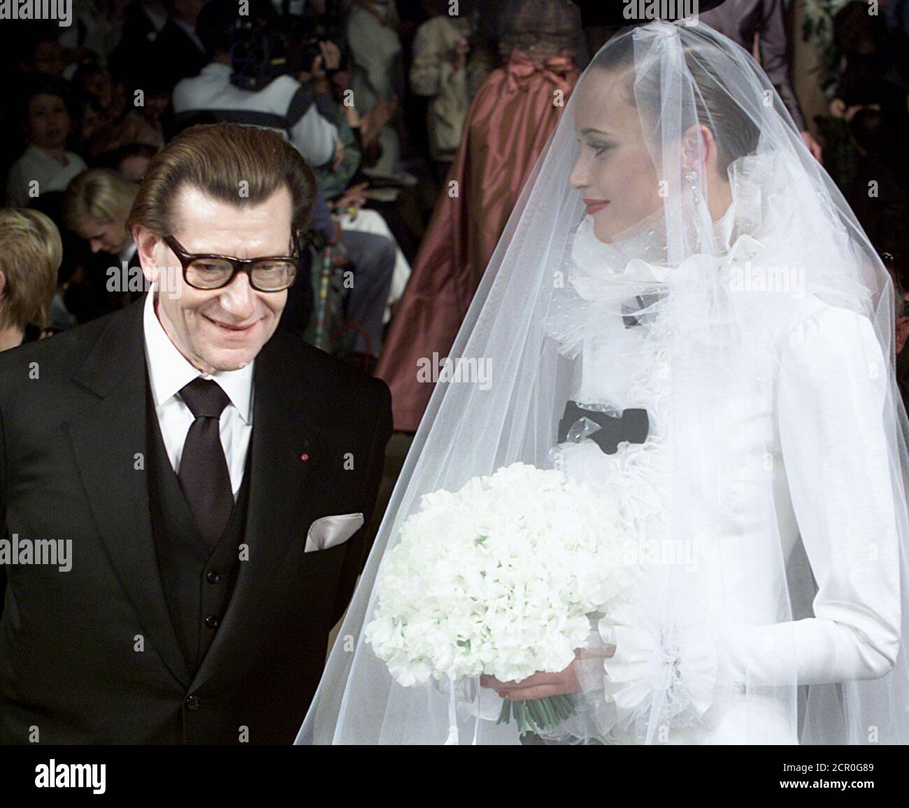 Robe De Mariée Yves Saint Laurent Le designer français Yves Saint-Laurent (L) est debout avec un modèle  portant une robe de mariée pour terminer sa collection de mode haute  Couture automne-hiver 2000-2001 juillet 12. JES/CLH Photo Stock -