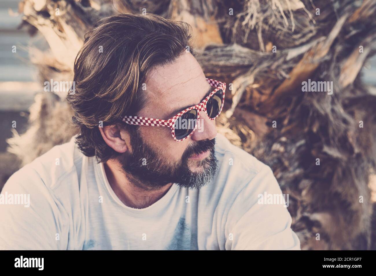Beau portrait d'homme caucasien adulte en extérieur avec des lunettes de soleil alternatives et la barbe Banque D'Images