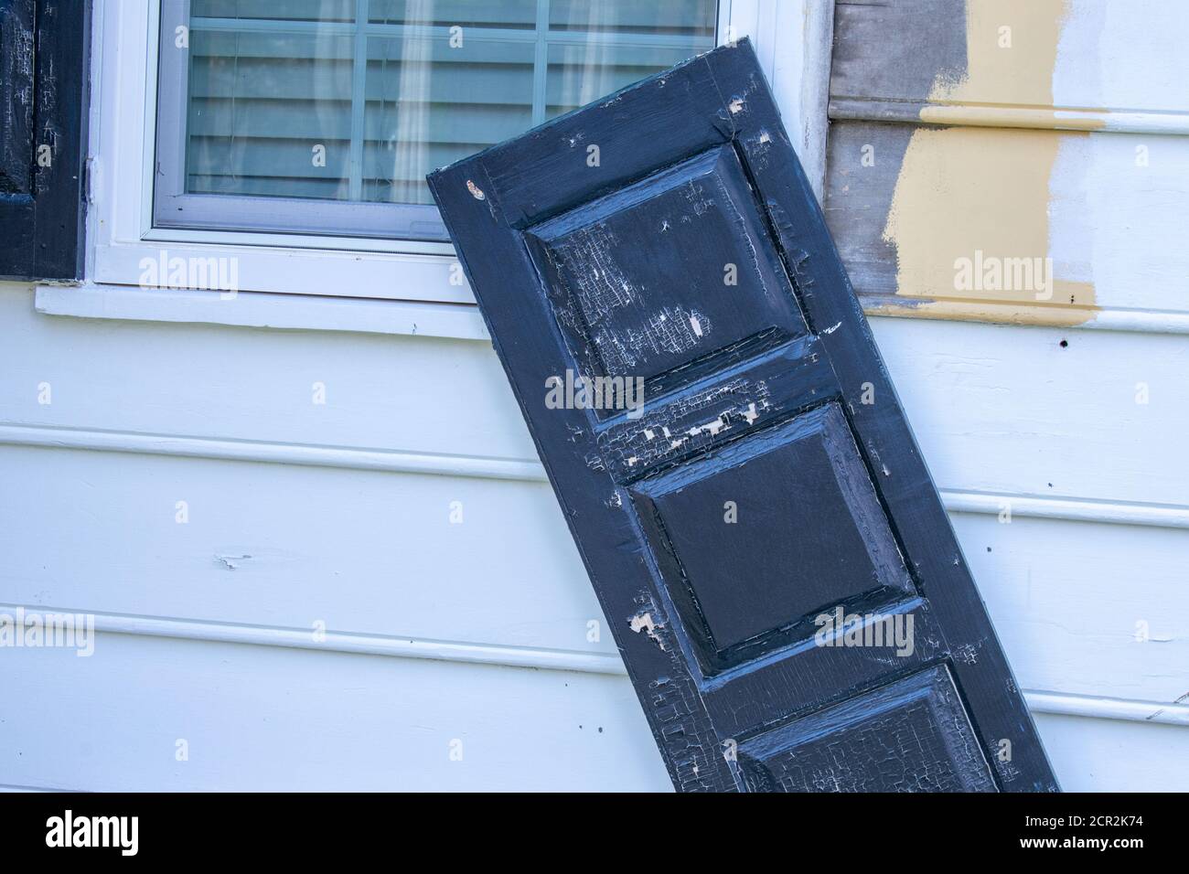 Un obturateur de fenêtre noir se fixe à peine sur le mur blanc Banque D'Images