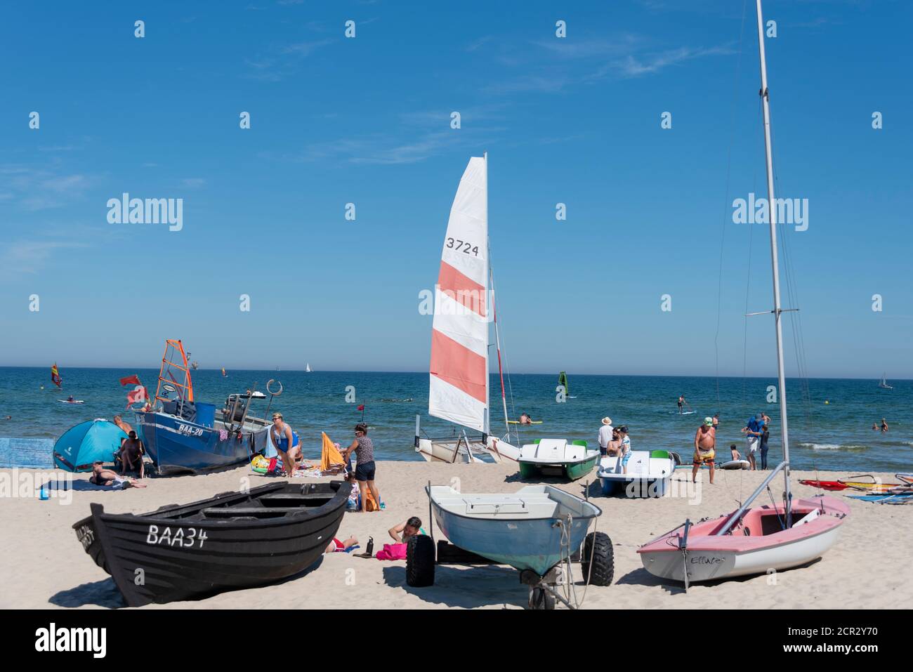 Allemagne, Mecklembourg-Poméranie occidentale, Île de Ruegen, Baabe, bateaux de pêche se trouvent à côté de petits bateaux à voile, les touristes se baignent au soleil sur la plage Banque D'Images