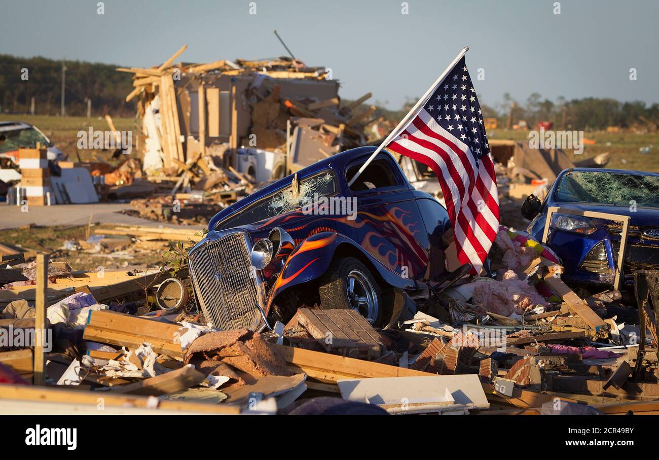 A U.S. flag sticks out the window of a damaged hot rod car in a suburban  area after a tornado near Vilonia, Arkansas April 28, 2014. On a second day  of ferocious