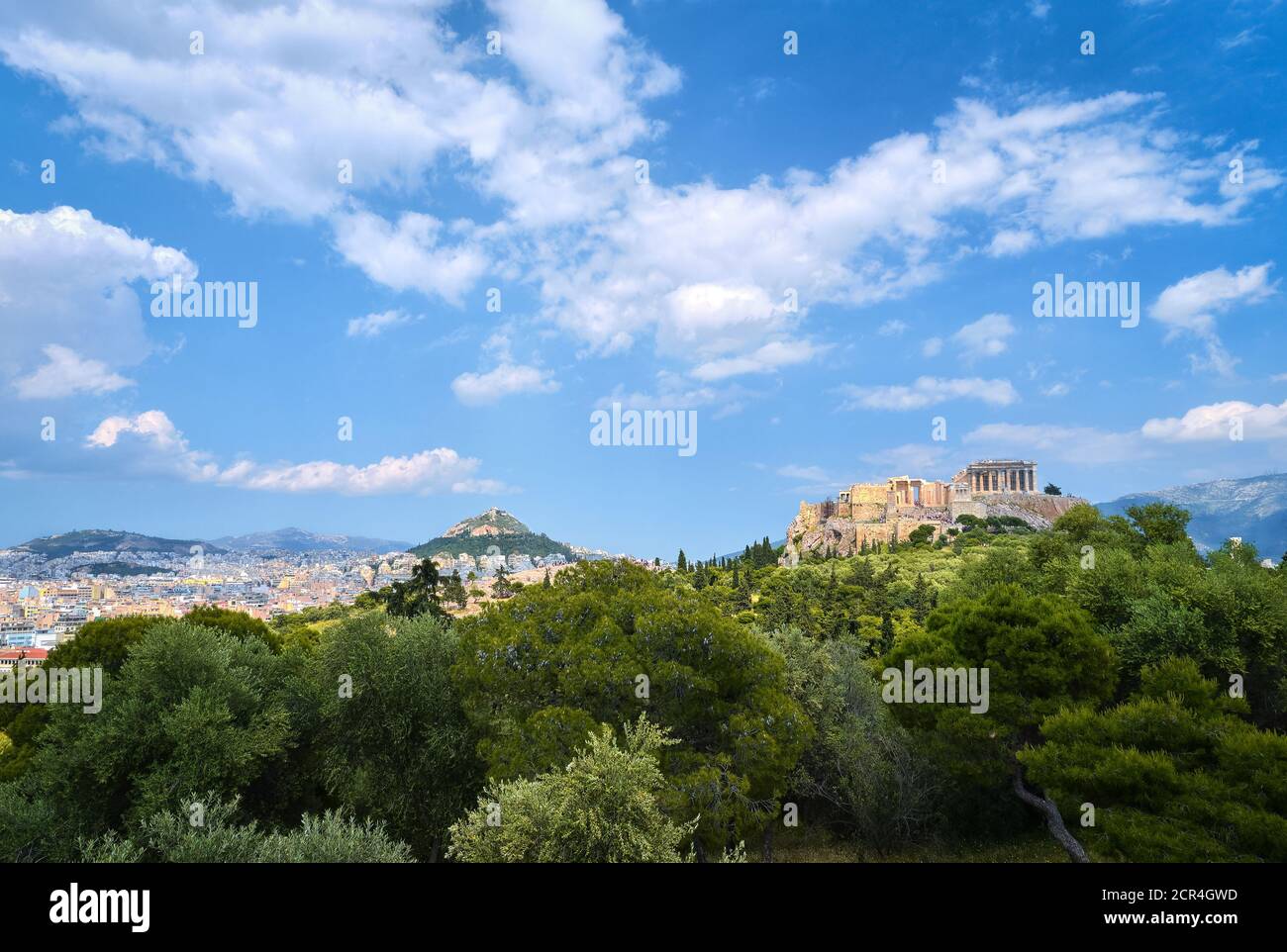 Vue emblématique de la colline de l'Acropole et de la colline du Lycabette en arrière-plan à Athènes, Grèce depuis la colline de Pnyx en été, avec de grands nuages dans le ciel bleu. Banque D'Images
