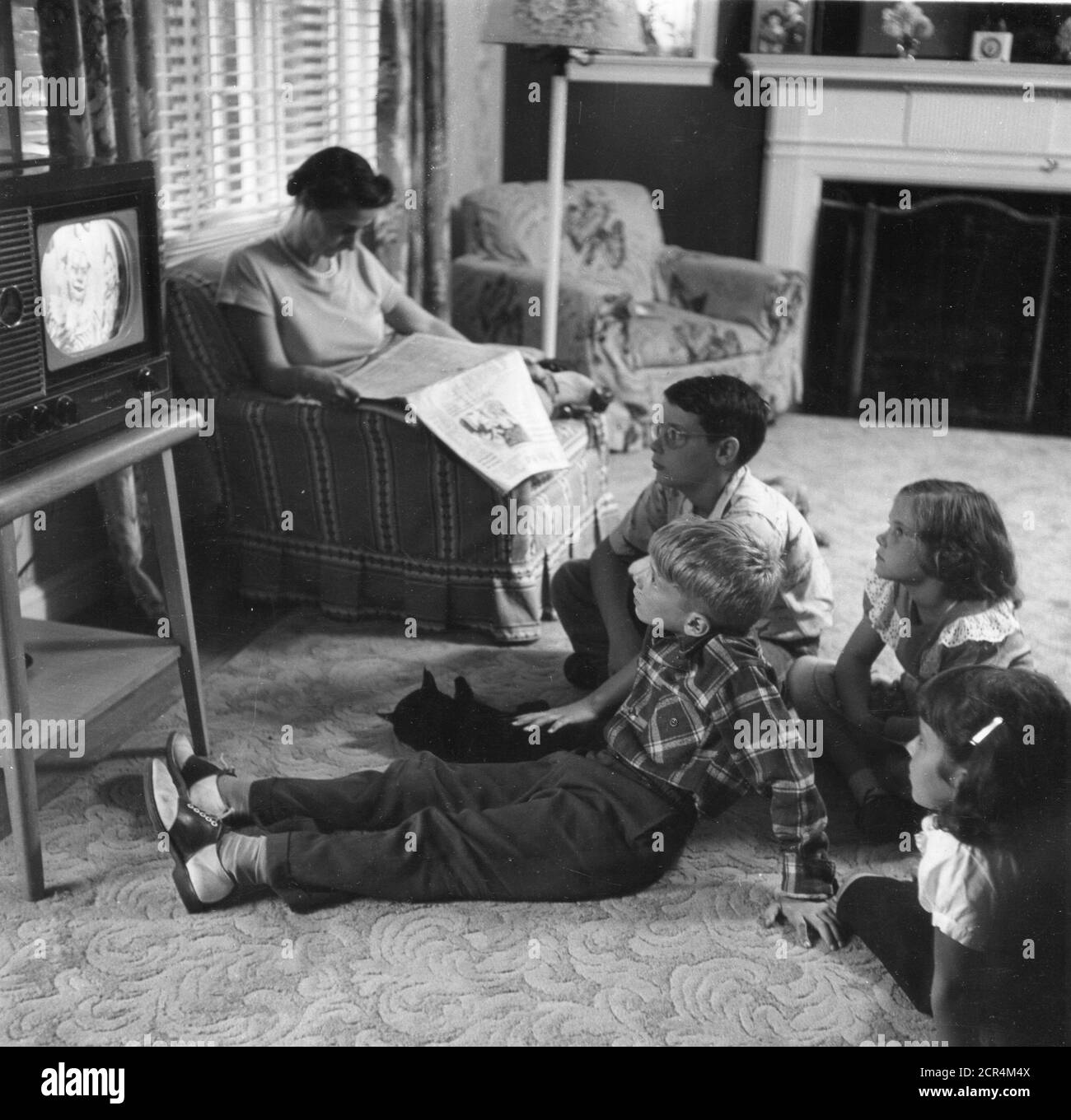 Une famille - mère, quatre enfants et animal de compagnie - apprécie la télévision dans leur salon, Washington, DC, 1955. (Photo de RBM Vintage Images) Banque D'Images