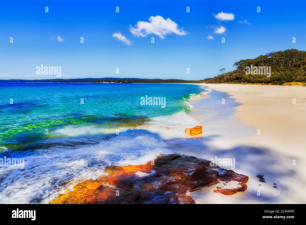 Vagues, soleil, roche, sable blanc et ciel bleu ingrédients de vacances d'été parfaites dans la baie de Jervis en Australie. Banque D'Images