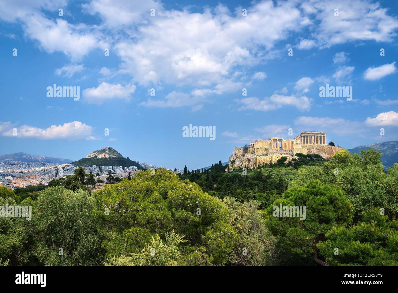 Vue emblématique de la colline de l'Acropole et de la colline du Lycabette en arrière-plan à Athènes, Grèce depuis la colline de Pnyx en été, avec de grands nuages dans le ciel bleu. Banque D'Images