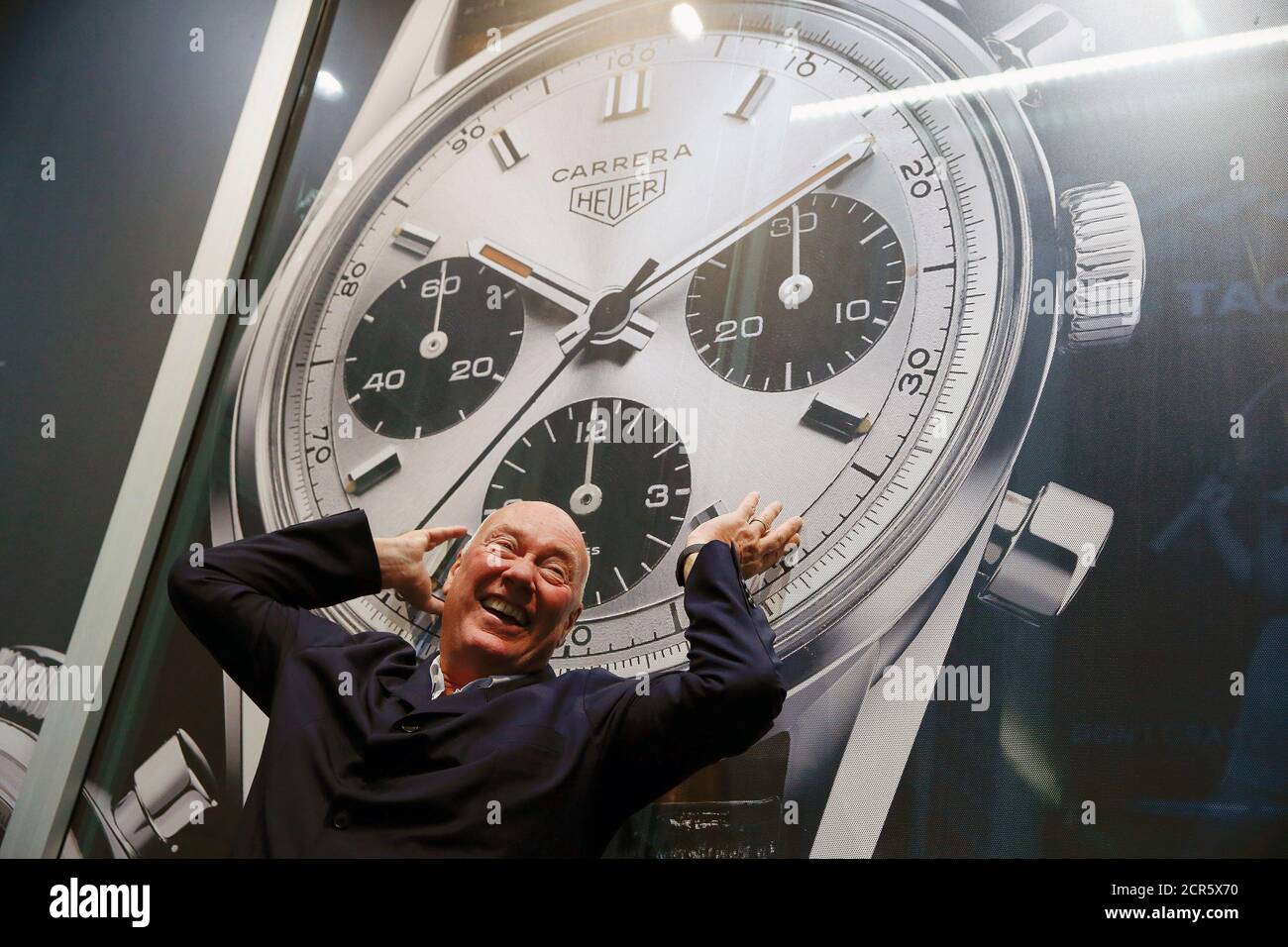 Jean-Claude Biver, directeur du groupe de produits de luxe français LVMH et  PDG par intérim de la plus grande marque de montres du groupe, TAG Heuer,  pose devant une affiche publicitaire avant