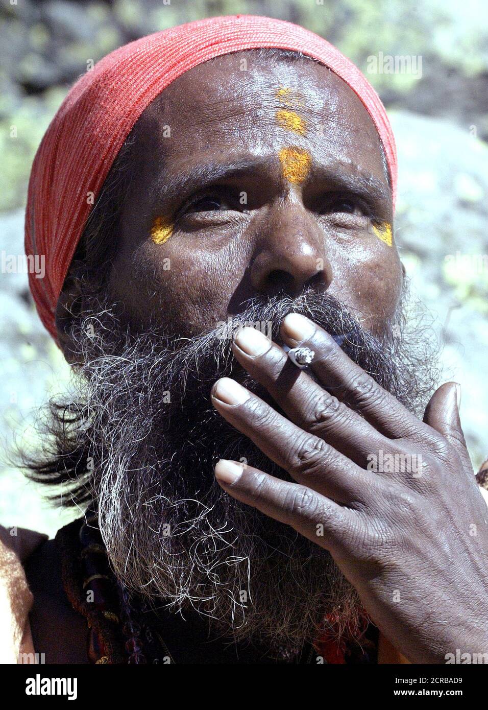 An Indian Hindu holy-man smokes a cigarette while taking a break, during  the trek to the holy cave of Amarnath in Chandanwari. An Indian Hindu  holy-man smokes a cigarette while taking a