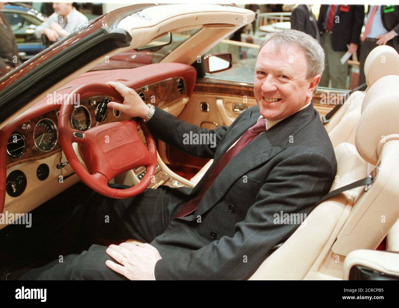 CEO of British luxury car maker Rolls Royce Tony Gott poses in the  company's newest convertible, the Corniche, which he introduced on January  10 at the North American International Auto Show at