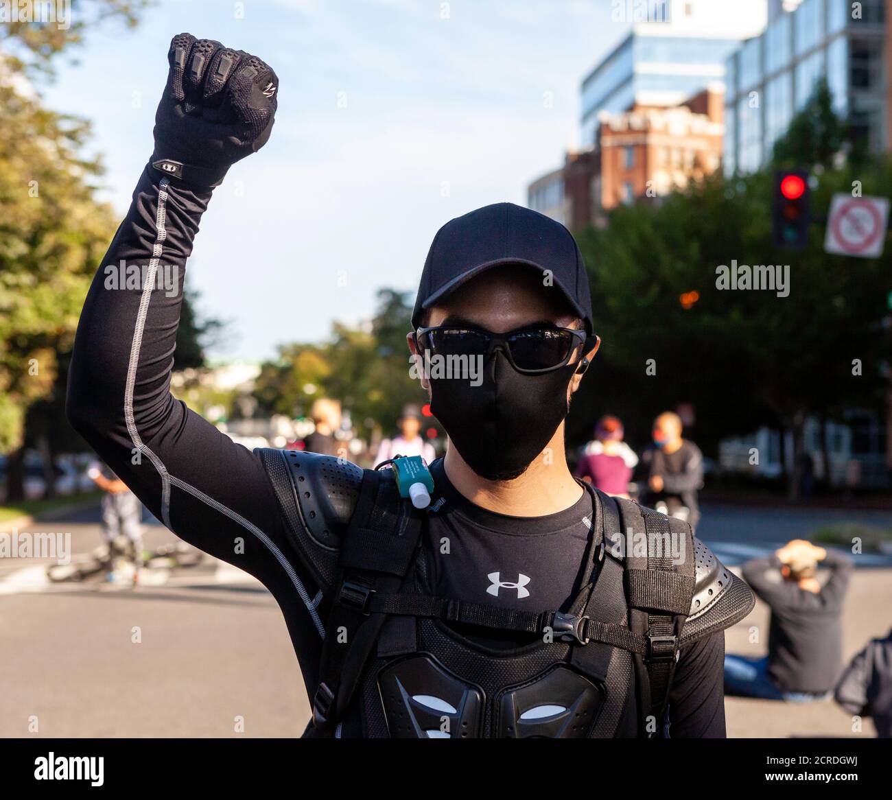 Washington, DC, Etats-Unis, 19 septembre 2020. En photo : un manifestant soulève un poing rebelle dans les airs après qu'il ait été poussé au sol par deux personnes prétendant être aux côtés des médias de droite. L'agression s'est produite sur Massachusetts Avenue alors que la Marche pour Justice se dirigeait vers le centre-ville de Washington. La Marche pour la justice est un événement hebdomadaire organisé par les manifestations de DC contre la brutalité policière et en faveur du financement de la police. Crédit : Allison C Bailey/Alay Live News Banque D'Images