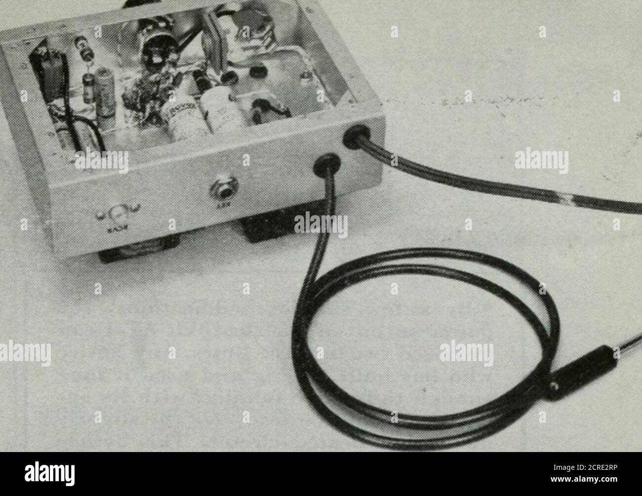 . TVQ . Moniteur C.W. et oscillateur de pratique de code. QST pour la vue de dessous montrant le câble de raccordement. Le triplet de sous-tension du cristal peut être vu dans le coin supérieur gauche de l'ehassi-;.. Les tensions de fonctionnement nécessaires. Un nouveau volttagetripler composé d'une moitié des 12AU7 et de deux diodes cristallines fournit les tensions pour le réglage de l'émetteur-récepteur et l'oscillateur audio. Cette tension est contrôlée par la clé de transmission et est mise en marche lorsque la clé est fermée. A ce niveau (lorsque la clé est fermée), le sideton est produit et le récepteur est calé par la tension négative sur le Banque D'Images