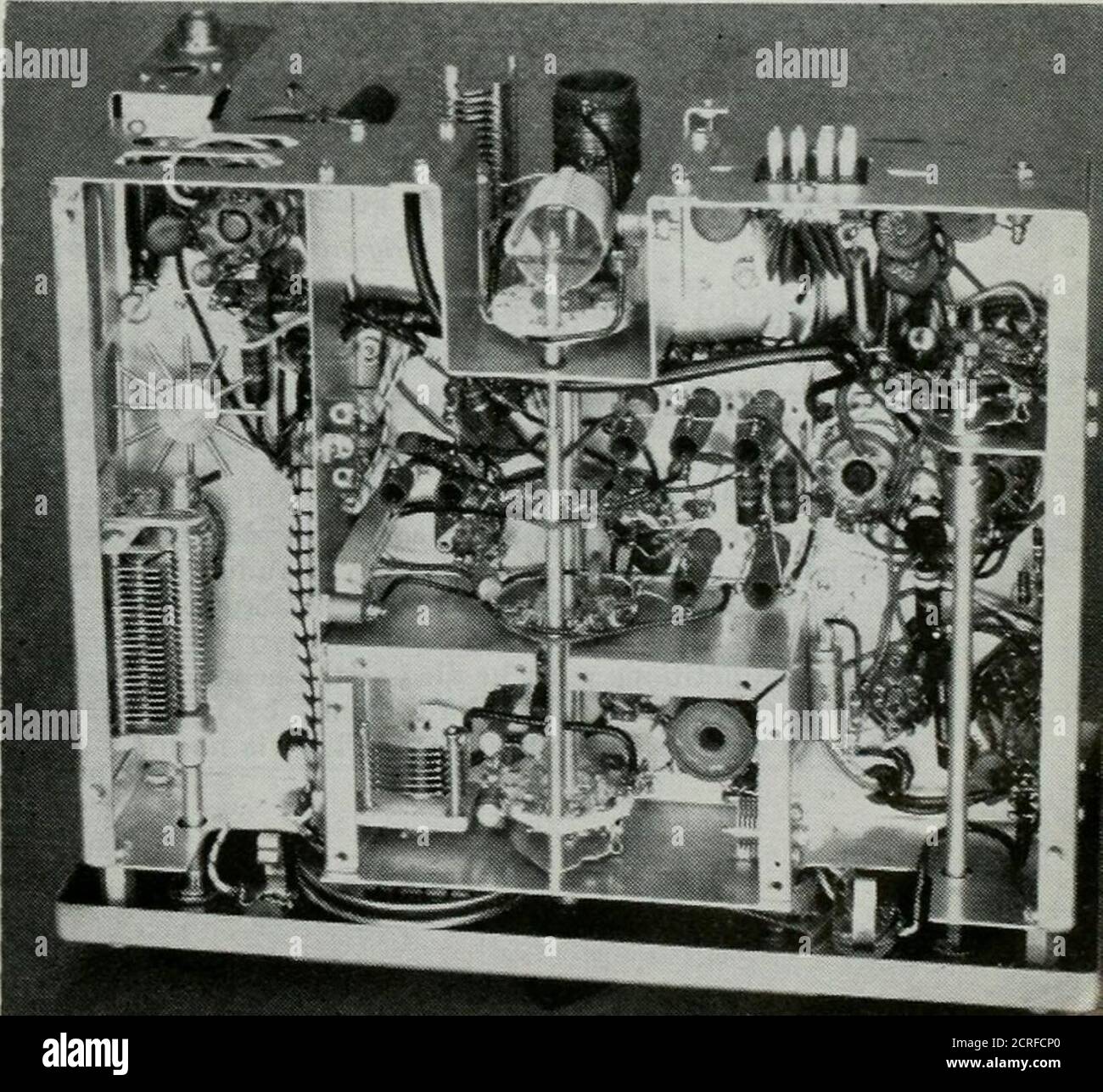 . QST . e chaque révolution. Ainsi, chaque fois que l'arbre du capacitateur effectue un tour complet, une capacité plus ou moins fixe est également projetée dans le circuit via le commutateur. Ce petit dispositif délicat peut être présent dans l'un des photograi)hs. Quand cr3Stal-contrull(il fonctionnement est désiré.les cristaux peuvent être changés du panneau avant en retirant la porte d'accès cristal sur la naneland en branchant le cristal désiré. Lorsque le fonctionnement VFOoperation est utilisé, une fiche de court-circuit est nécessaire dans la prise du cristal. Le circuit de l'oscillateur est en partie dans la Fig. 2 — il est un peu inhabituel en ce que le circuit VFOTuned est utilisé pour le caoutchouc Banque D'Images