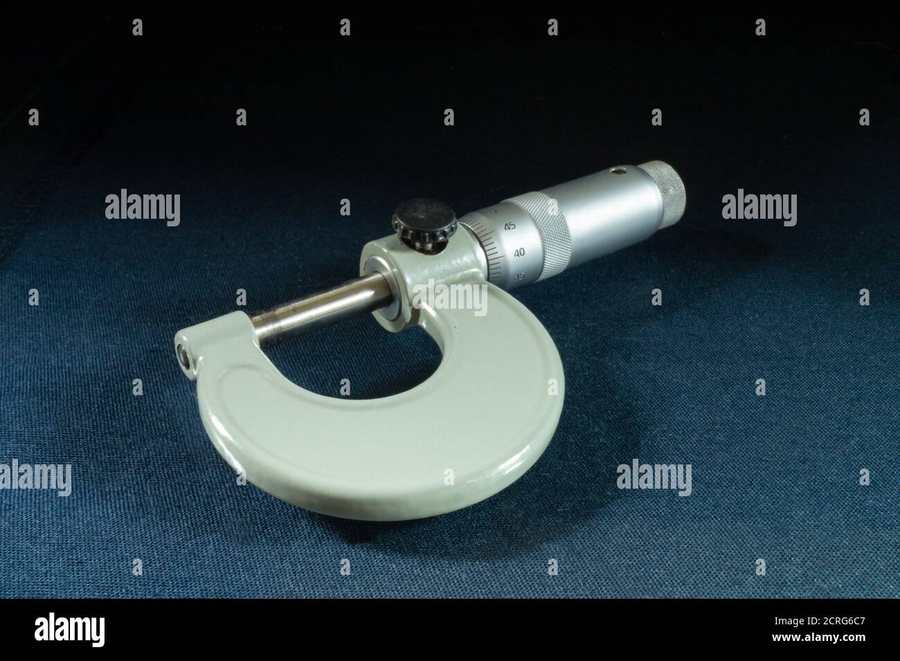 Le micromètre de l'instrument activé fait passer la table en bleu sur le noir Background.instrument mécanique pour la mesure à partir d'aciers Banque D'Images