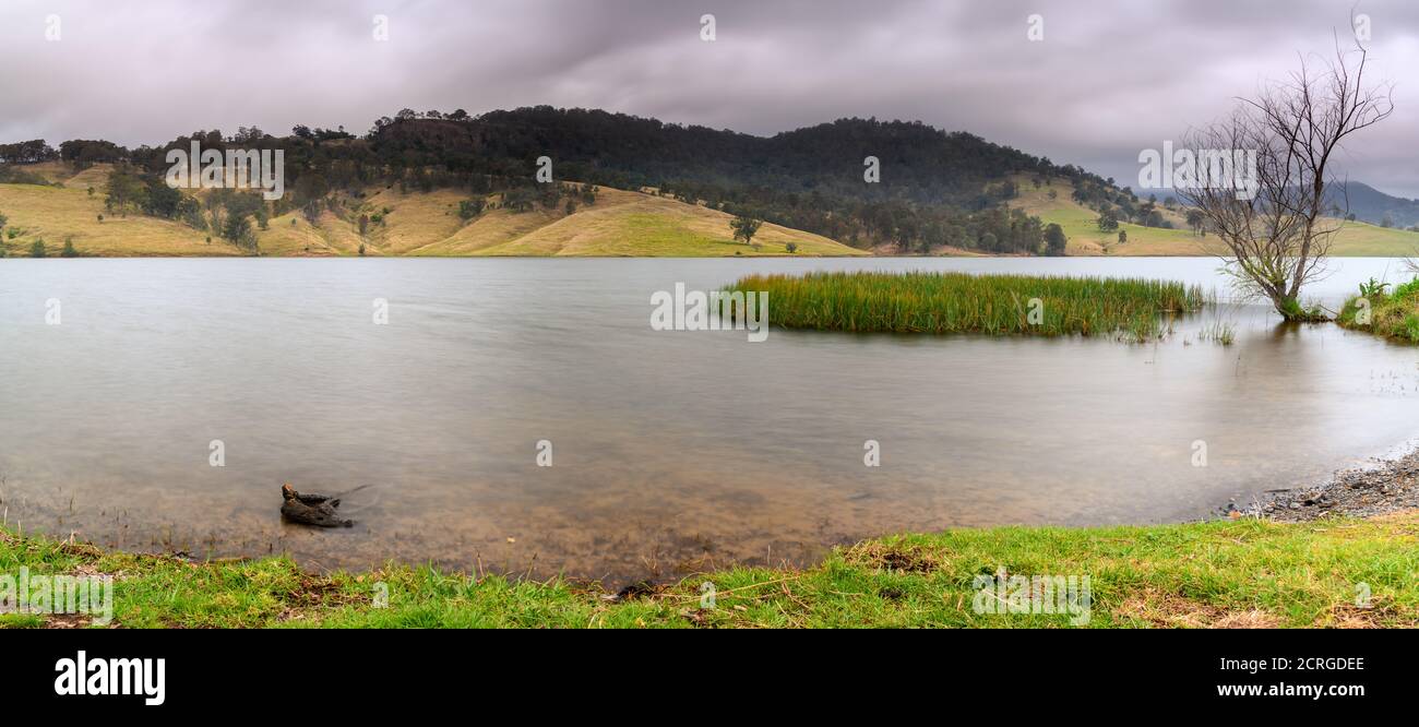 Paysage aquatique pittoresque du barrage de Lostock avec un ciel couvert et les montagnes et collines environnantes. À Lostock, dans l'Upper Hunter de Nouvelle-Galles du Sud, en Australie. Banque D'Images