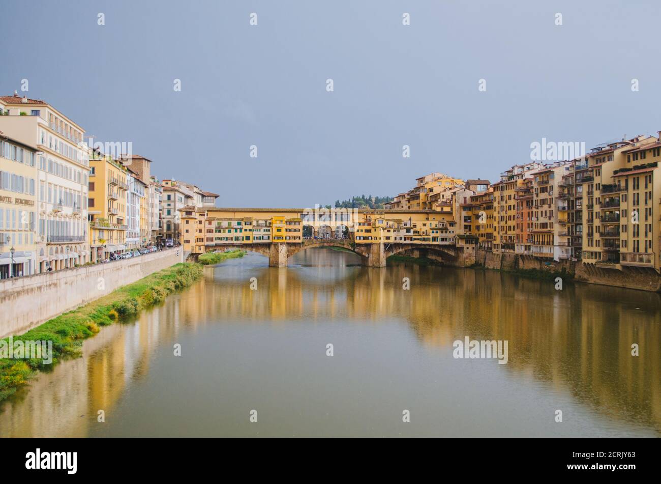 Rome, Italie - UNE vue panoramique sur le Ponte Vecchio et l'Arno reflétant les bâtiments dans son eau pendant un après-midi nuageux. Banque D'Images