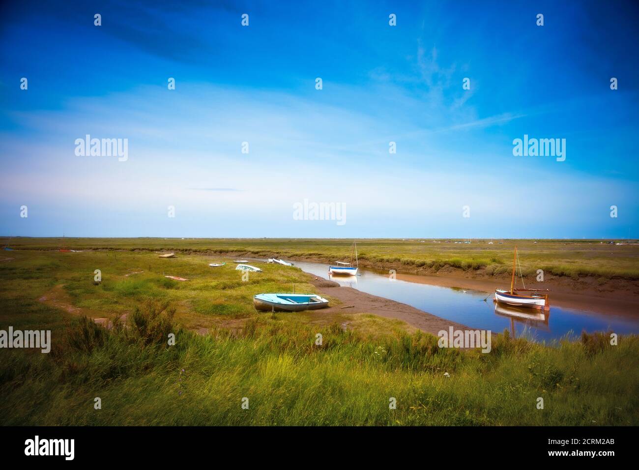 Bateaux à l'embouchure de Blakeney point, sur la côte de Norfolk, pendant que la marée est sortie. Banque D'Images