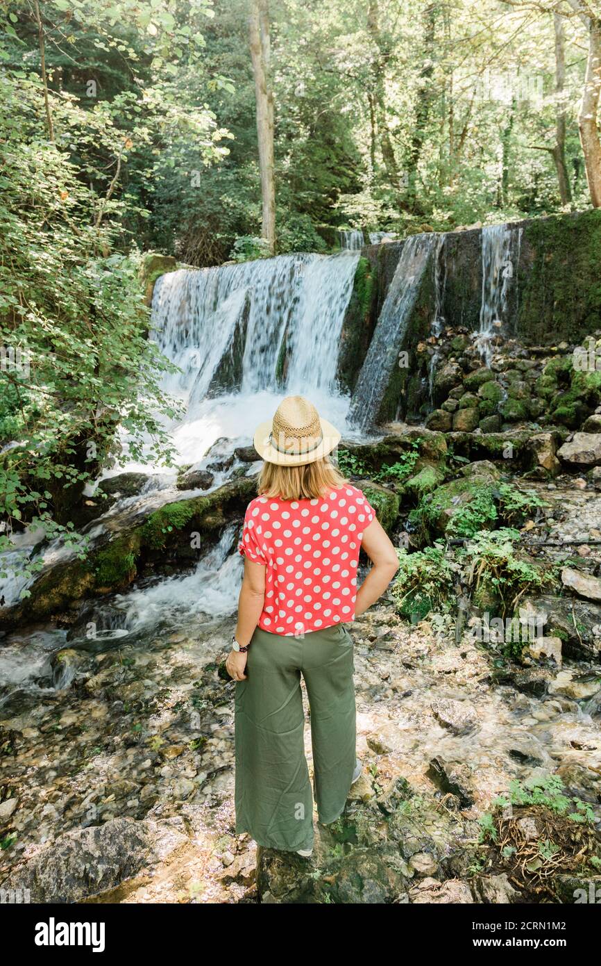 Jeune femme explorateur de la nature debout devant la cascade Banque D'Images