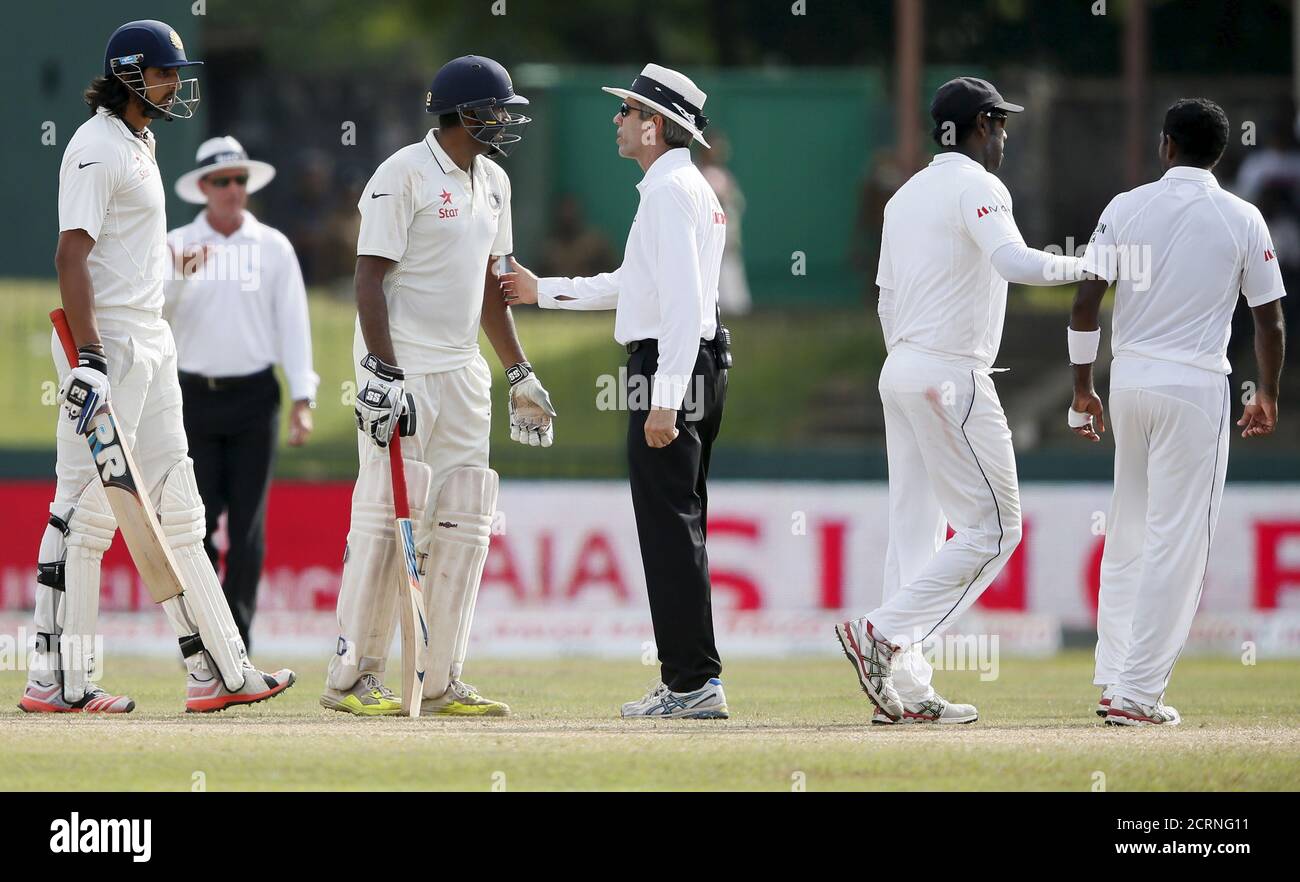 Le juge-arbitre Nigel Llong (C) parle avec Ishant Sharma (L) de l'Inde et Ravichandran Ashwin (2e L) comme capitaine du Sri Lanka Angelo Mathews (2e R) conduit Dhammika Prasad loin d'un argument avec Sharma pendant le quatrième jour de leur troisième et dernier match de cricket à Colombo le 31 août 2015. REUTERS/Dinuka Liyanawatte Banque D'Images