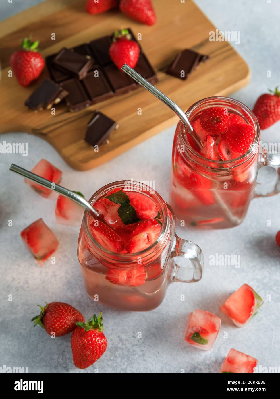 Cocktail de fraises avec baies et planche en bois avec chocolat. Régime boisson et concept sain Banque D'Images