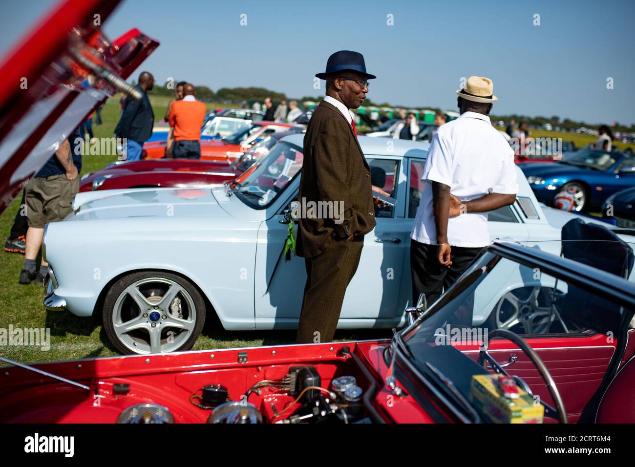 Membres du Club de voiture classique et sportive afro-antillaise lors de l'événement de fin de semaine « Classic car Drive in Weekend » à Bicester Heritage. Banque D'Images