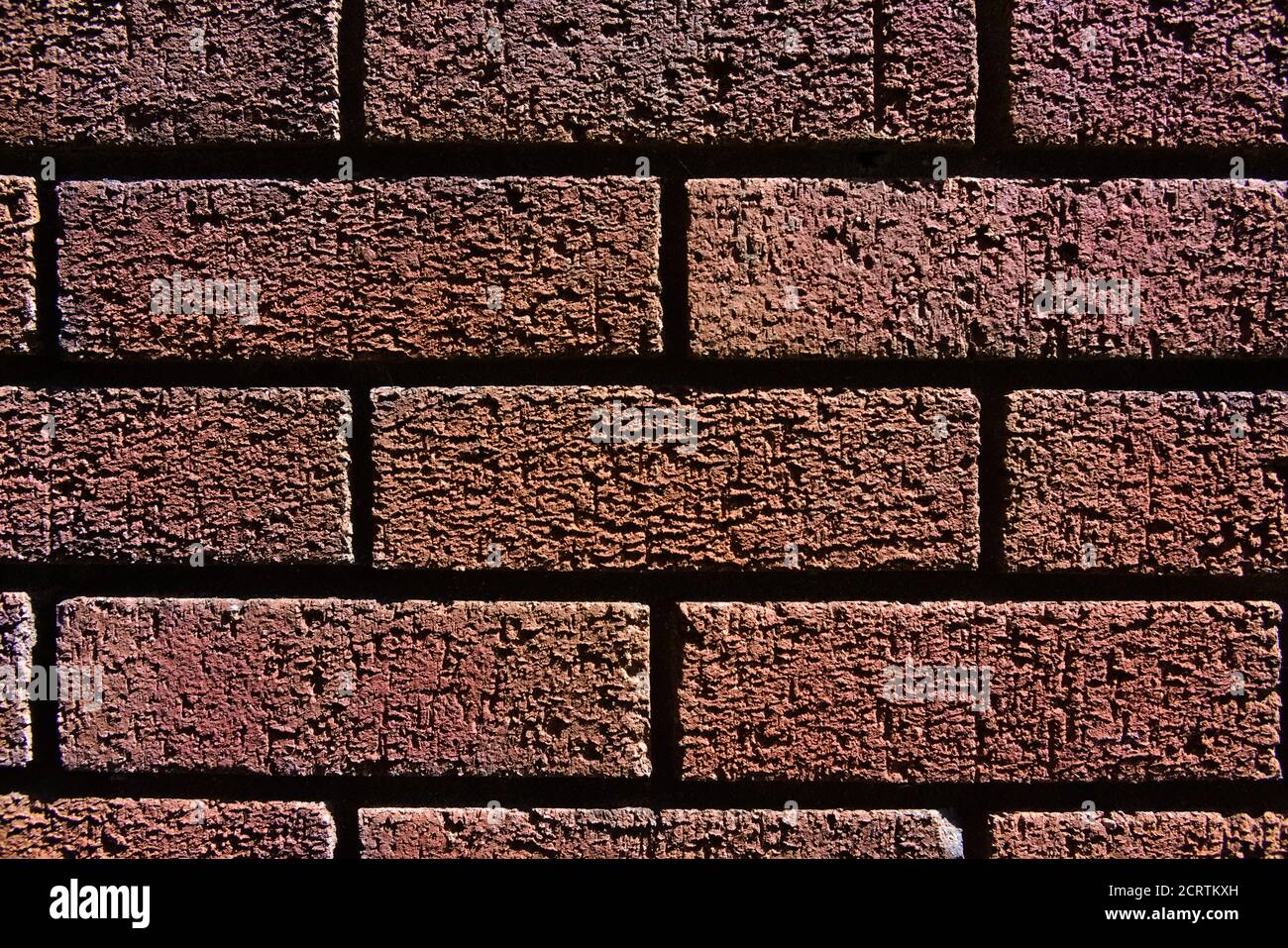 1 - texture d'arrière-plan de mur de briques rouges horizontales. Apparence monochromatique et ombres sombres entre les briques. Banque D'Images