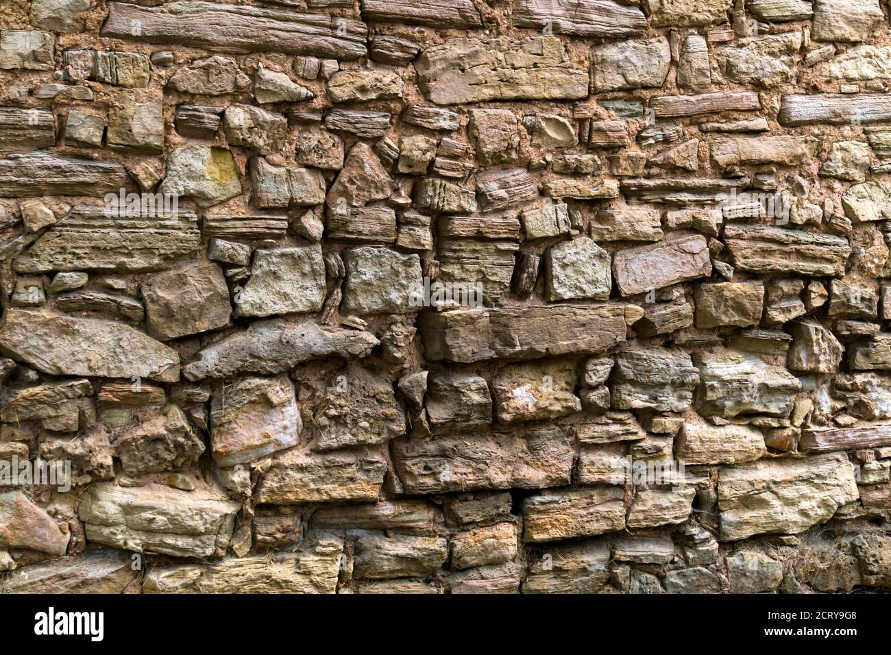 Un vieux mur de pierre de pavés maintenus ensemble par de l'argile. Banque D'Images