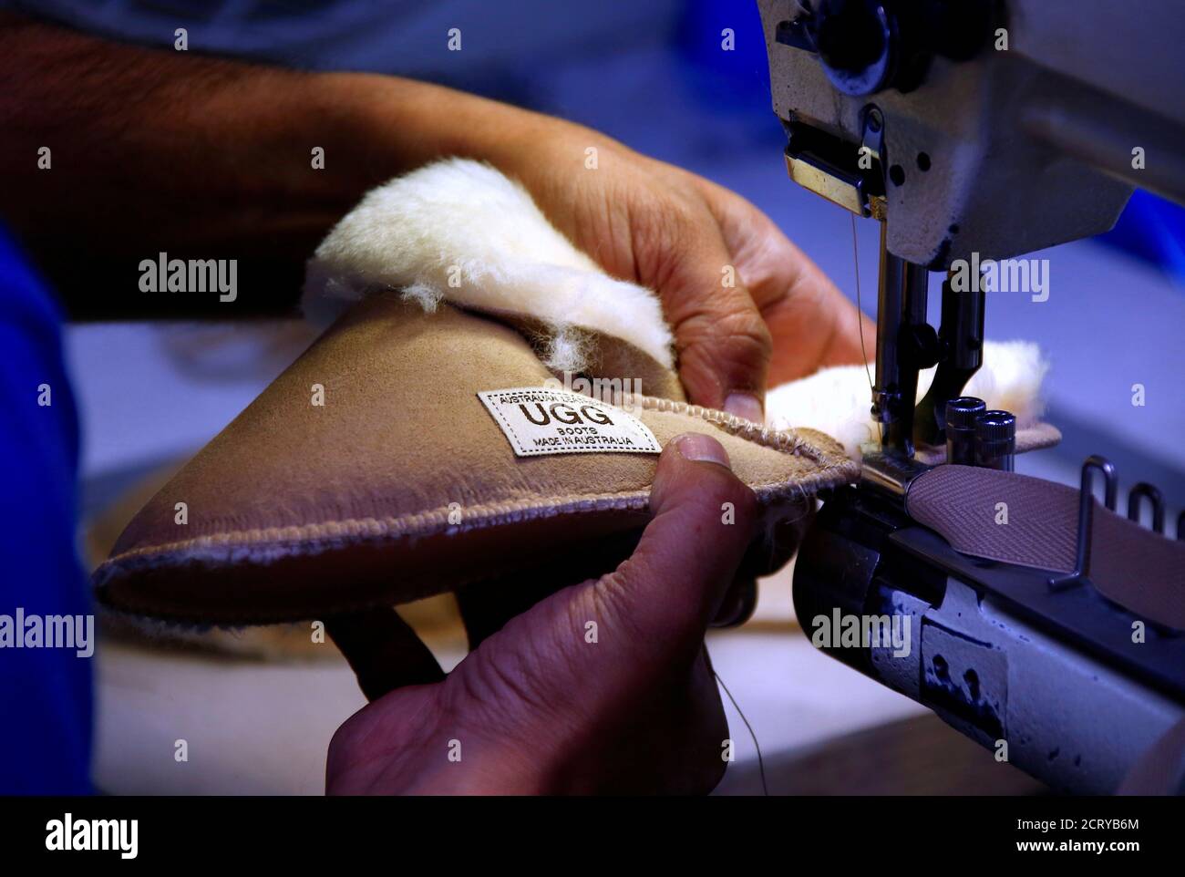 Un travailleur utilise une machine à coudre dans une usine qui fabrique des bottes  UGG de peau de mouton contrefaites dans l'ouest de Sydney, en Australie, le  26 octobre 2016, pour produire