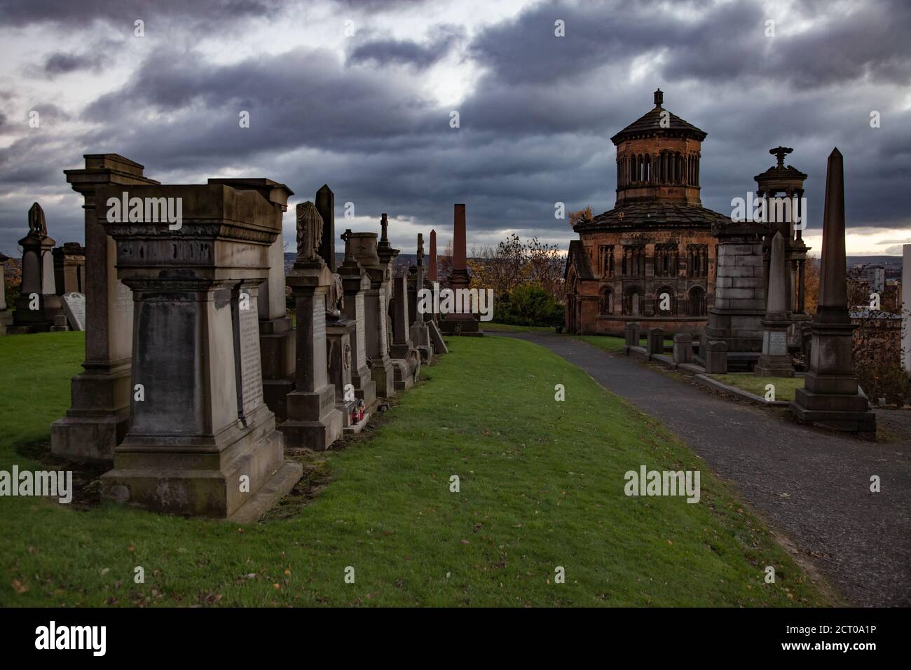 Glasgow/Écosse - 13 novembre 2013 : la colline de la nécropole de Glasgow en mauvais temps. Monuments graves et mausolée. Herbe verte et arbres jaunes. Nuages de tempête gris. Banque D'Images