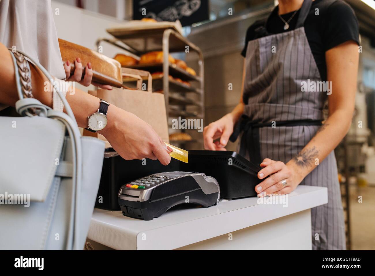 Payer avec sa carte de crédit dans une boulangerie, faire un achat Banque D'Images