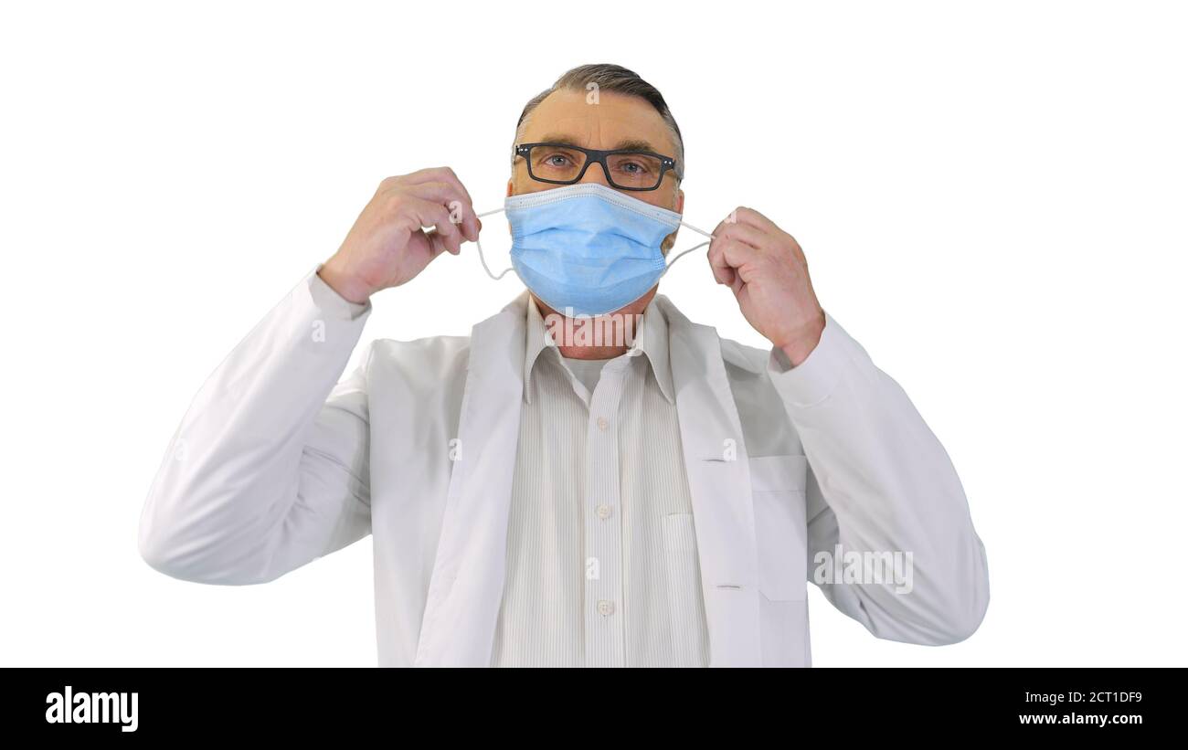 Homme médecin prenant le masque médical de protection et souriant à env Banque D'Images