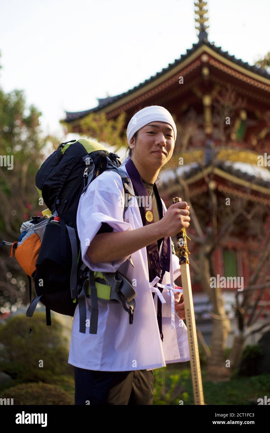 Jeune pèlerin japonais (Henro) portant l'équipement rituel (chemise blanche, personnel en bois) sur le pèlerinage de Shikoku de 88 temples, Japon 2012. Banque D'Images