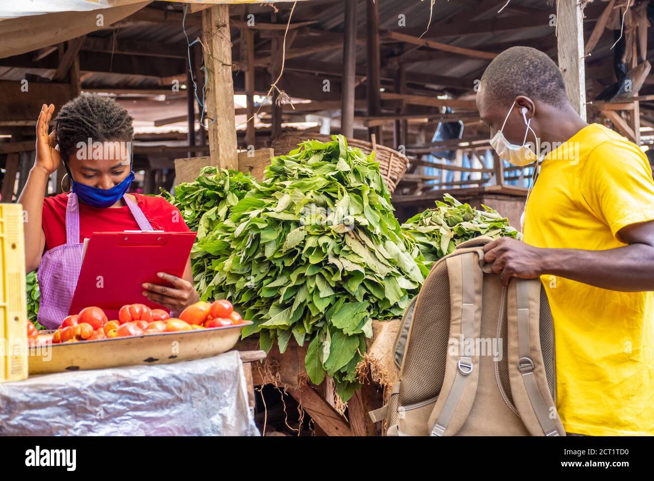 le préposé à la livraison prend un colis d'un africain local négociant de marché Banque D'Images