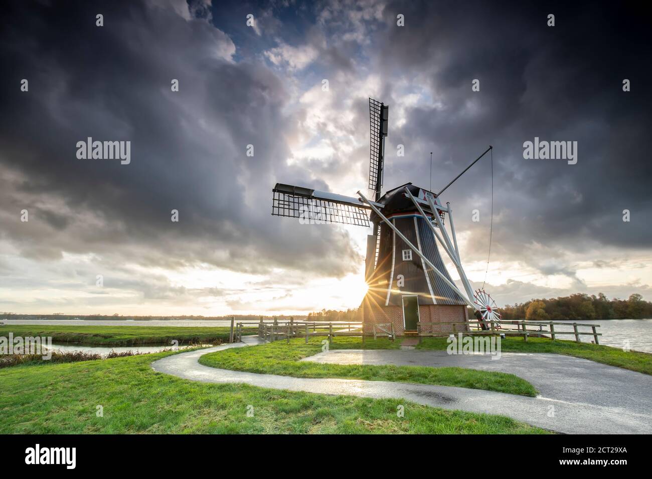 Soleil derrière le moulin à vent hollandais après la tempête Banque D'Images